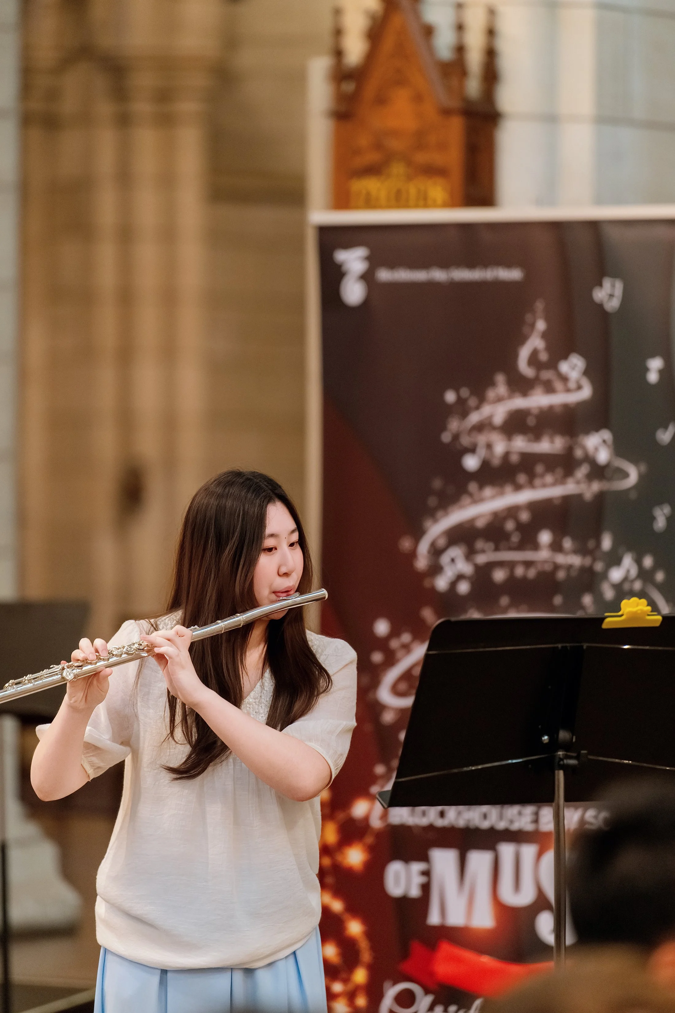 Young woman playing the flute during a musical performance.