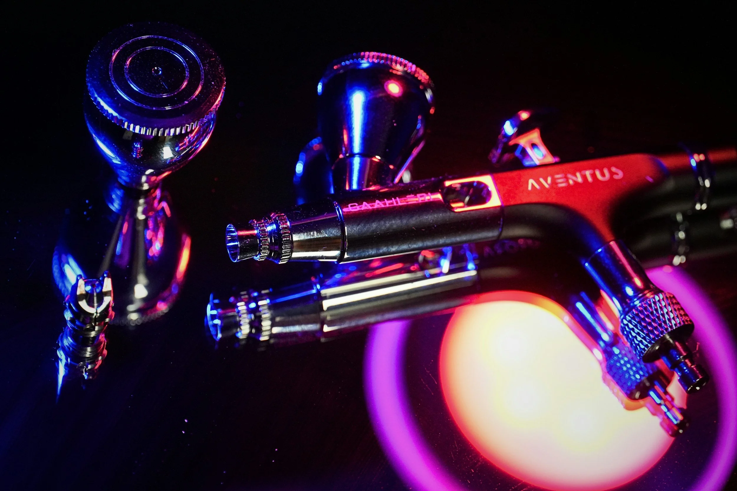picture of an airbrush front end on a shiny surface. 