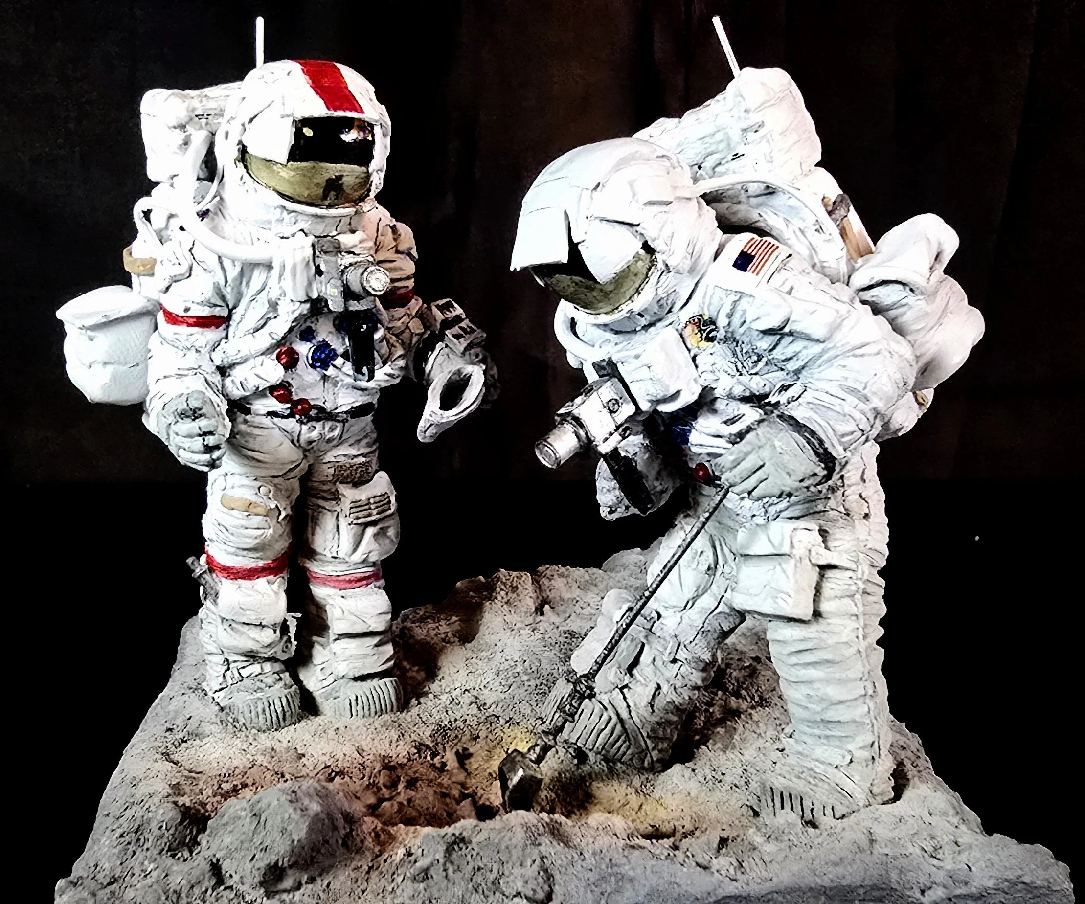 Two astronauts in space suits celebrating on the moon, with one making a fist pump and the other holding a flag, against a black background.