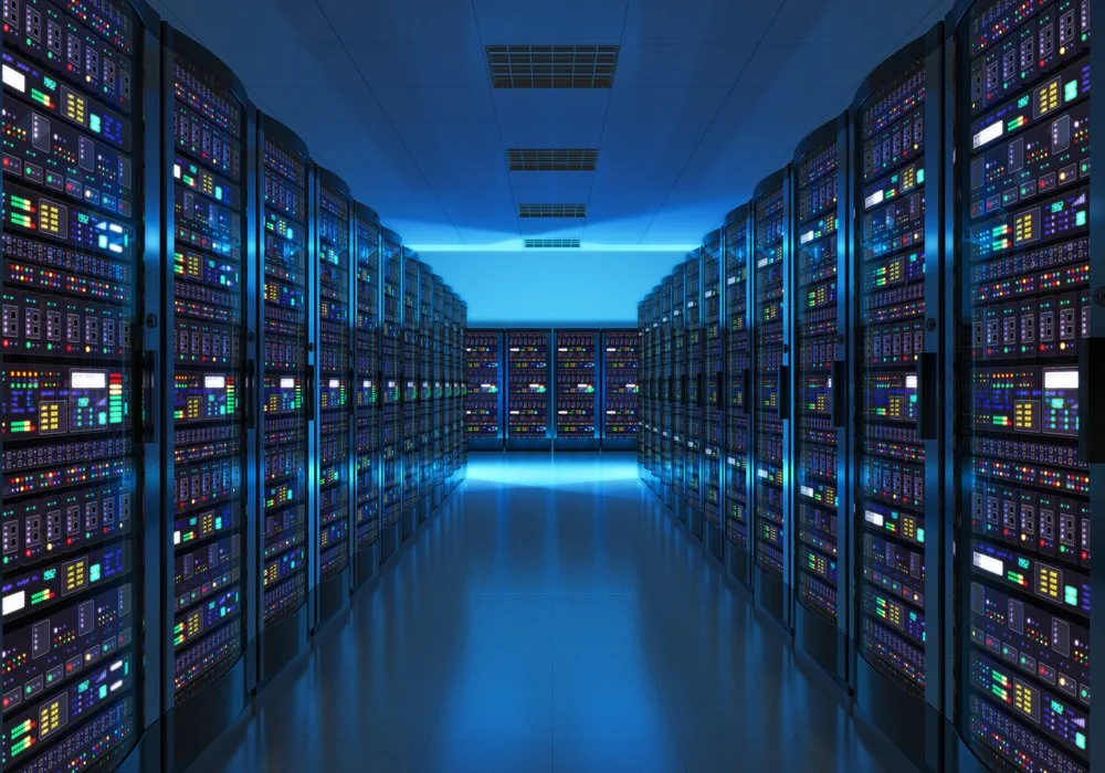 A data center with multiple server racks illuminated by blue lighting.