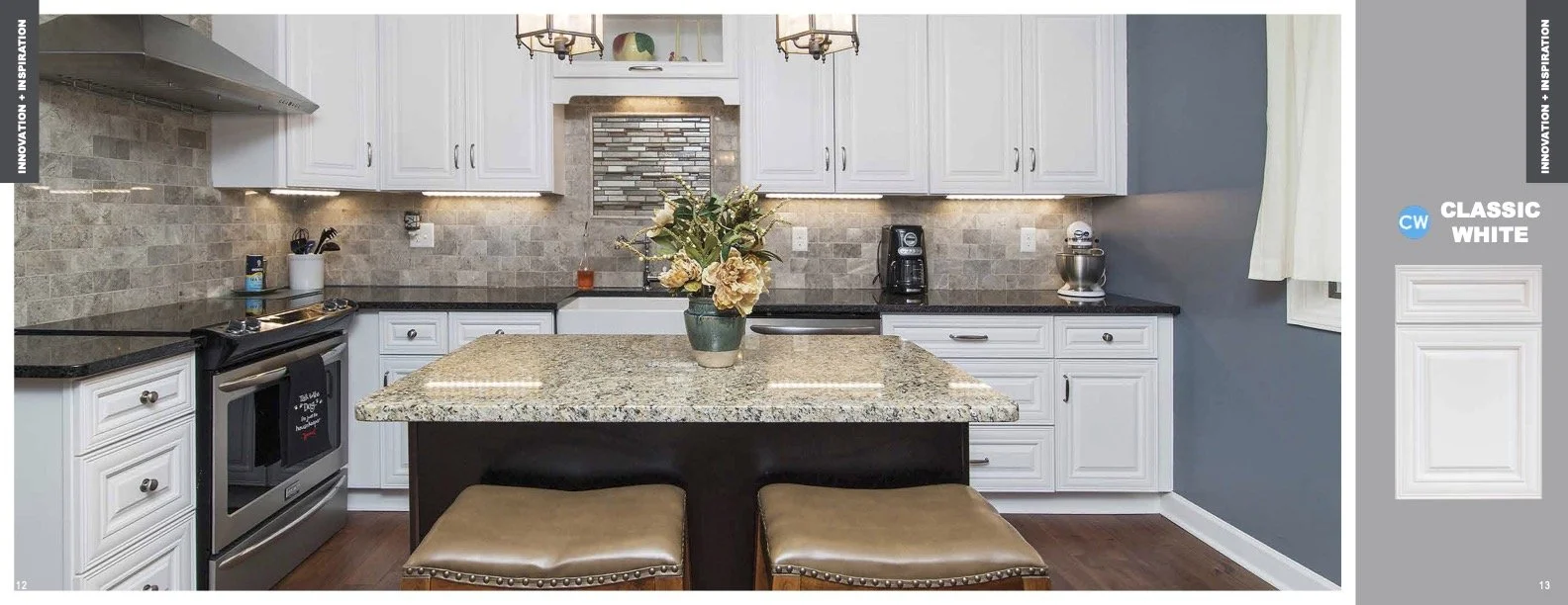 A modern kitchen with white cabinets, granite countertops, a small island with flowers, and dark hardwood floors.