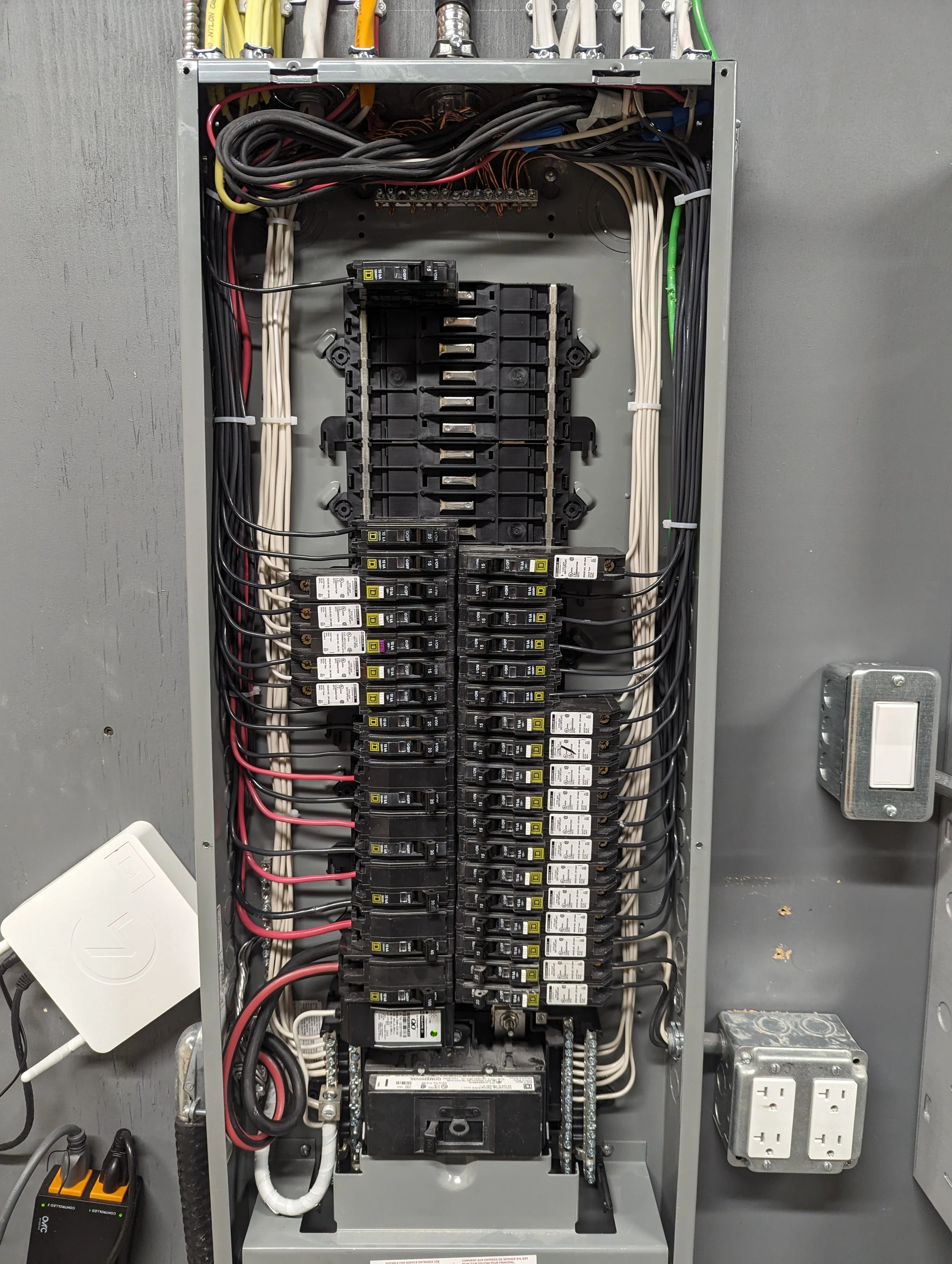 A closed electrical panel containing numerous circuit breakers, wiring, and electrical connections.