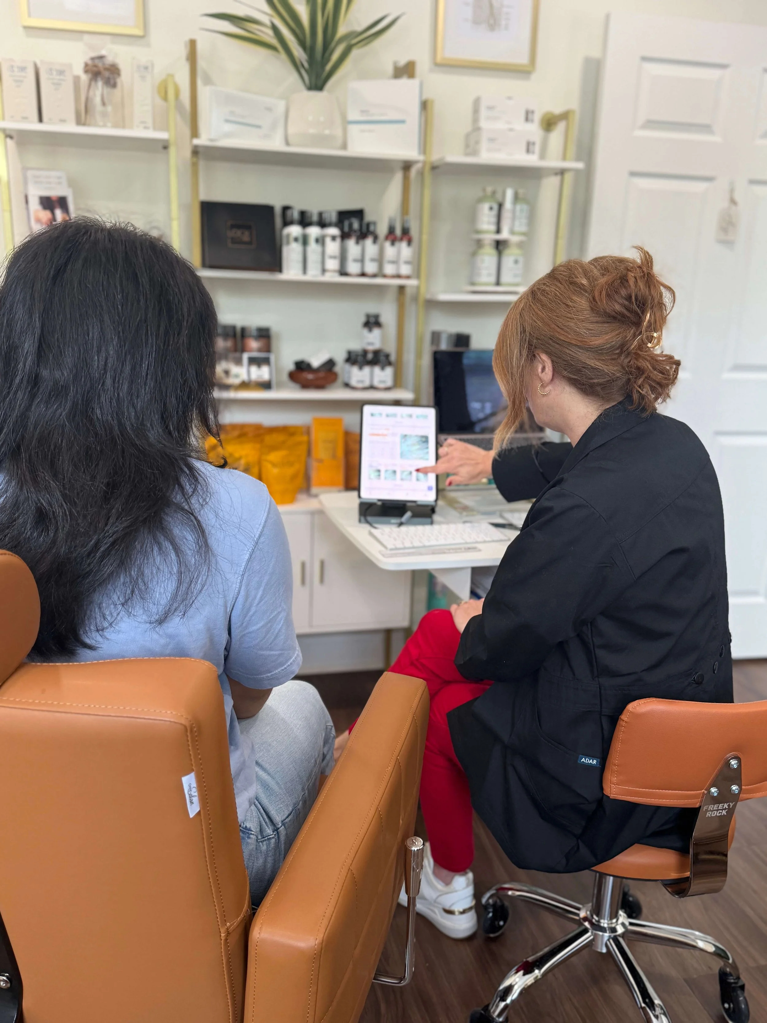 Suzi Watkins, board-certified trichologist at Root Revival Hair Restoration, reviewing a client's hair and scalp analysis during a personalized Hair & Scalp Evaluation in Cumming, Georgia.