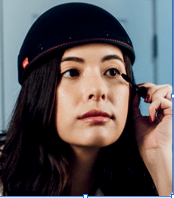 Woman wearing a Revian red light therapy cap as part of a hair loss support program.
