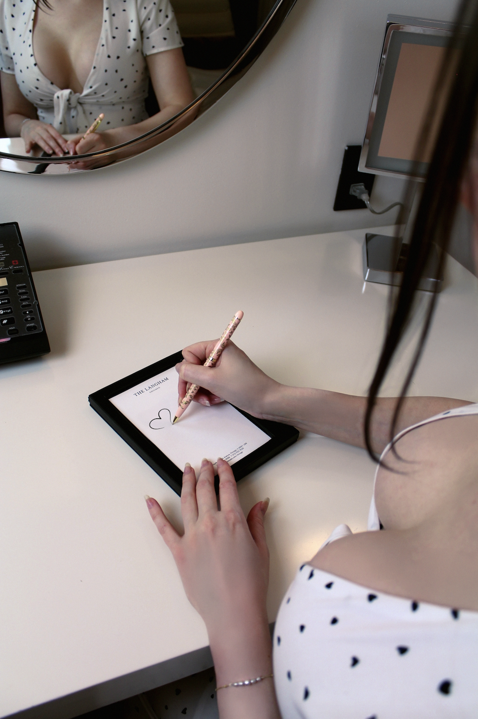 Peeking over Juliette's shoulder to see her doodling on a notepad.