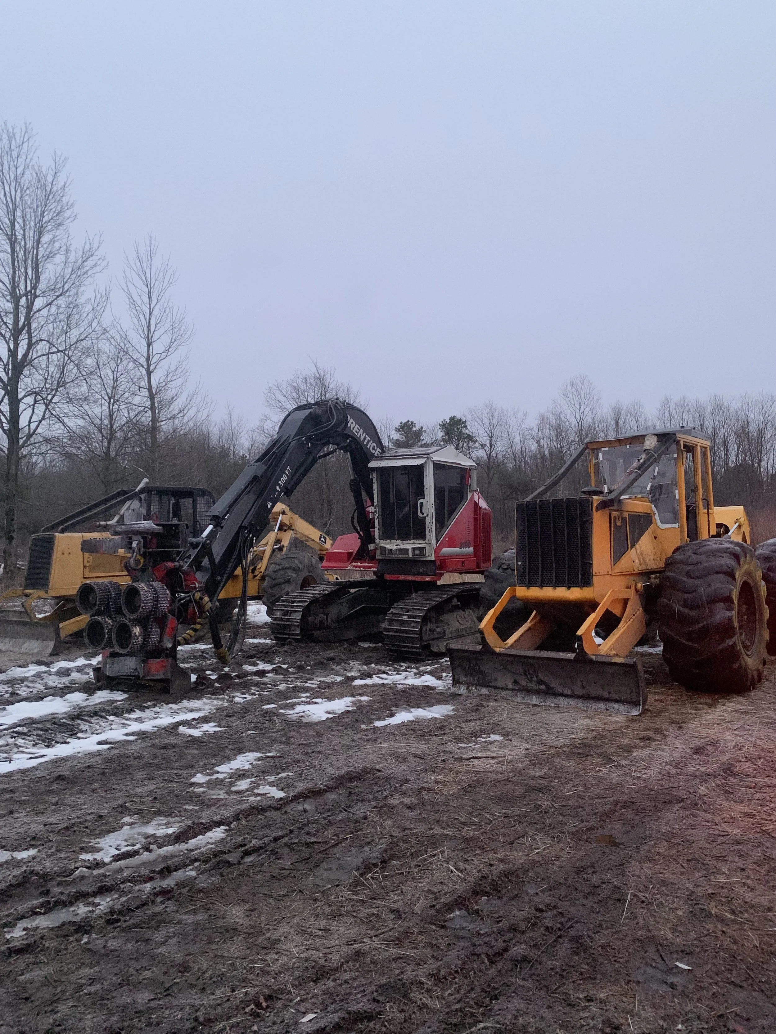 Prentice 2190 Track Harvester, John Deere 648G Log Skidder and a John Deere 648D Log Skidder on a logging job landing.
