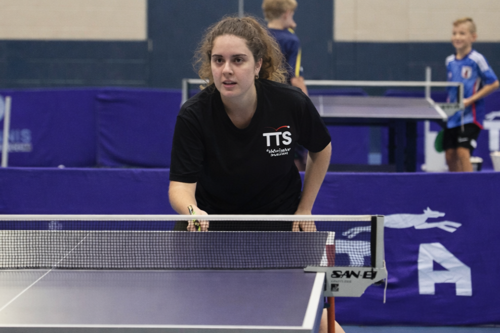 A young woman playing table tennis.