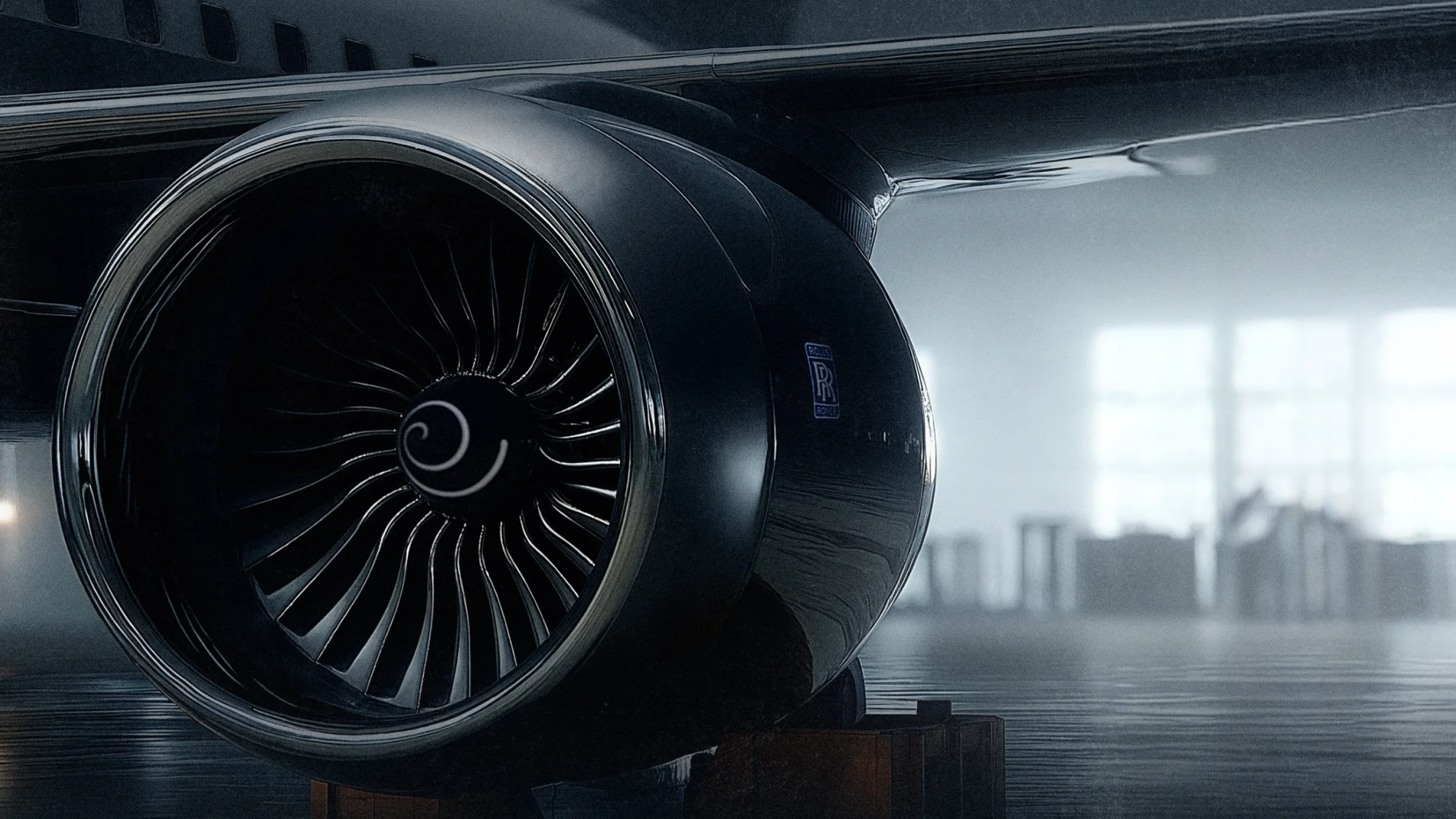 Close-up of a Rolls-Royce jet engine on a plane indoors with window light in the background.