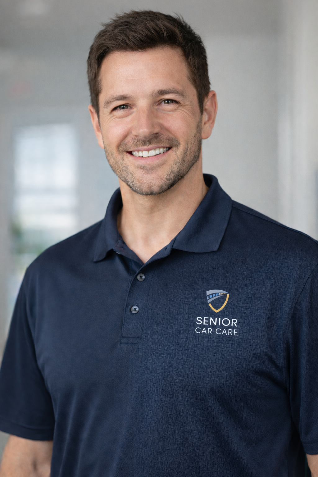 Young male professional wearing a blue polo shit with the Senior Car Care logo on the left chest