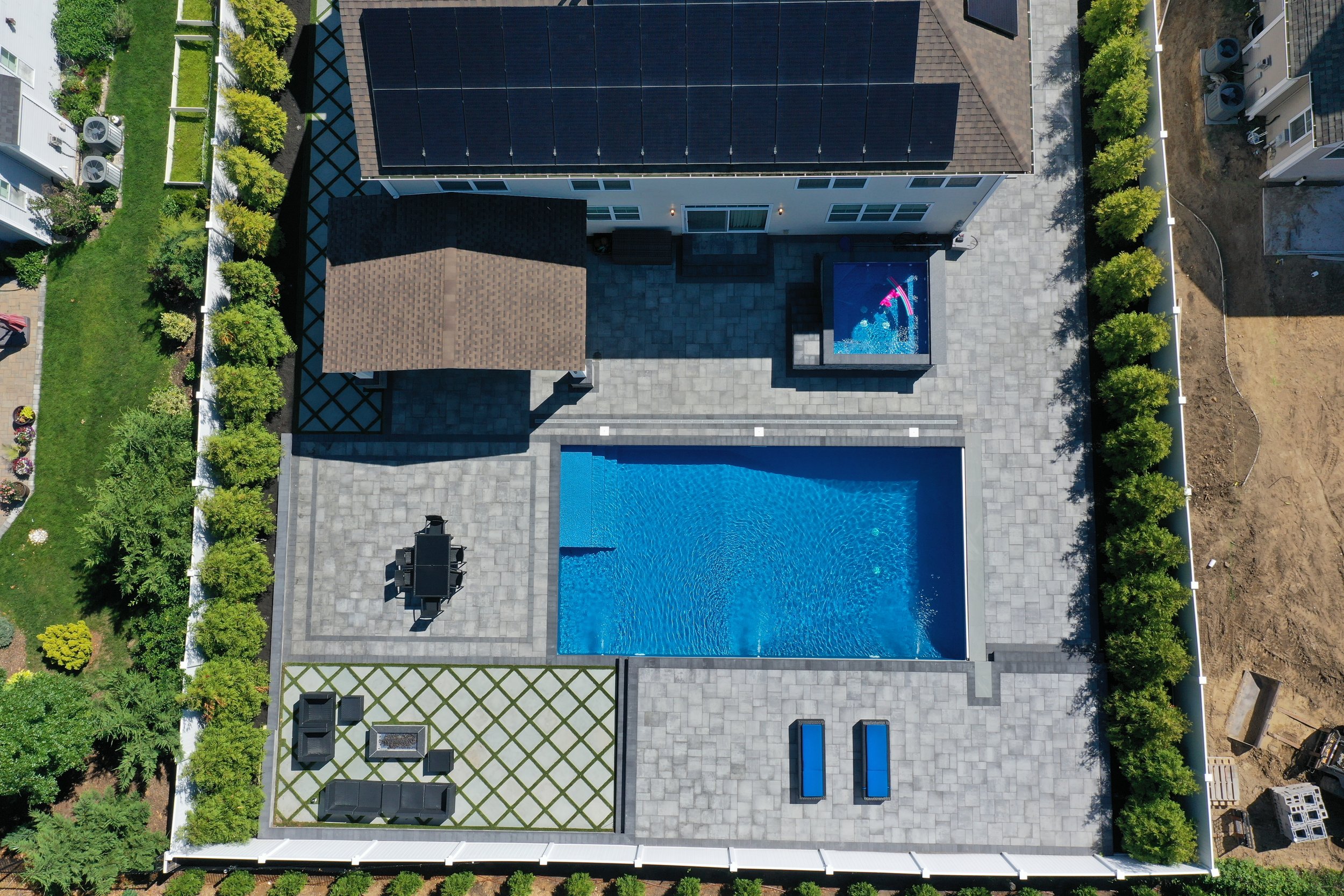 Complete backyard makeover with inground pool, hot tub, fire pit, outdoor kitchen, and paver patio in Ridge, NY