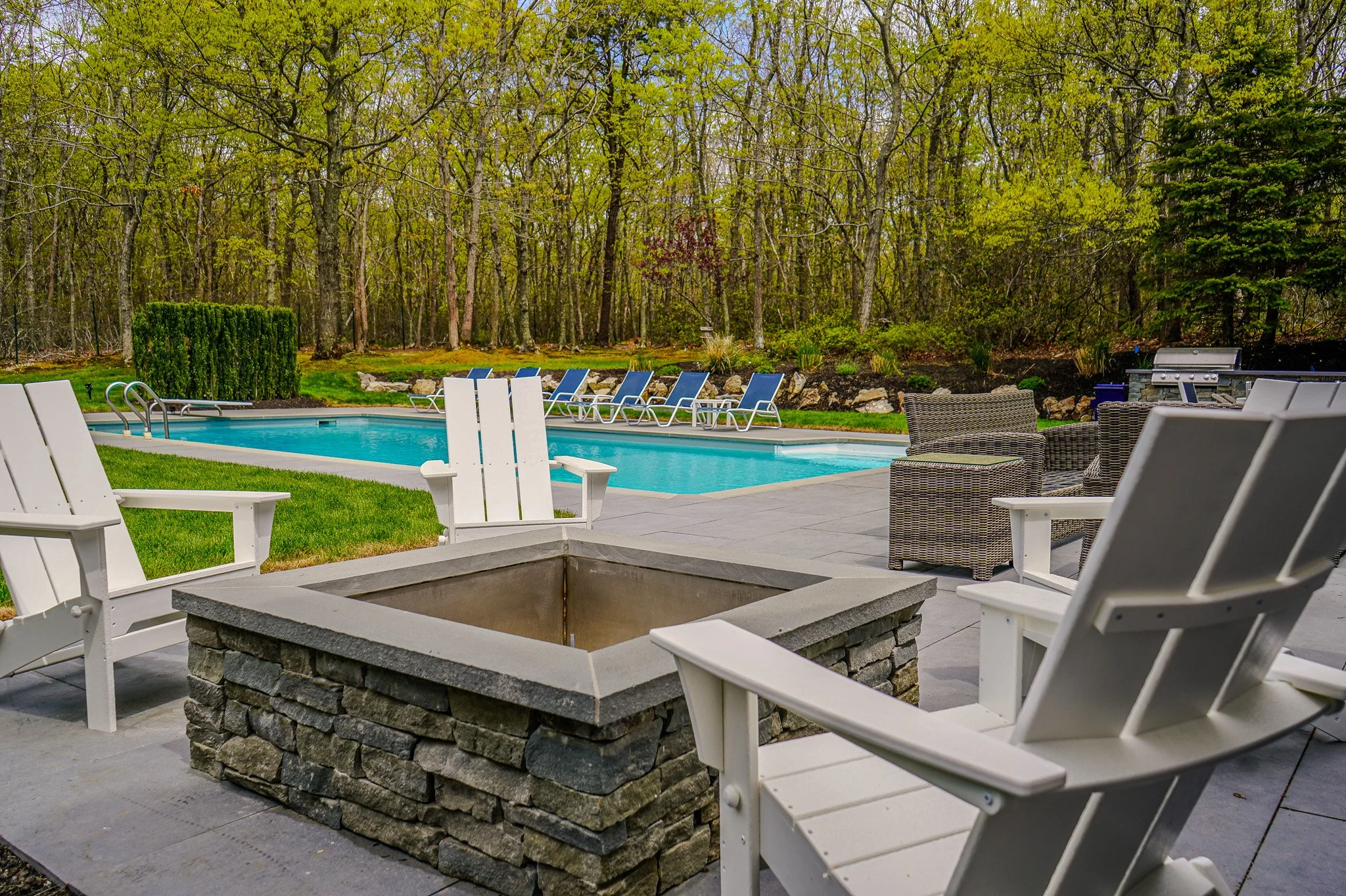 Backyard with a swimming pool, lounge chairs, outdoor seating, and a fire pit