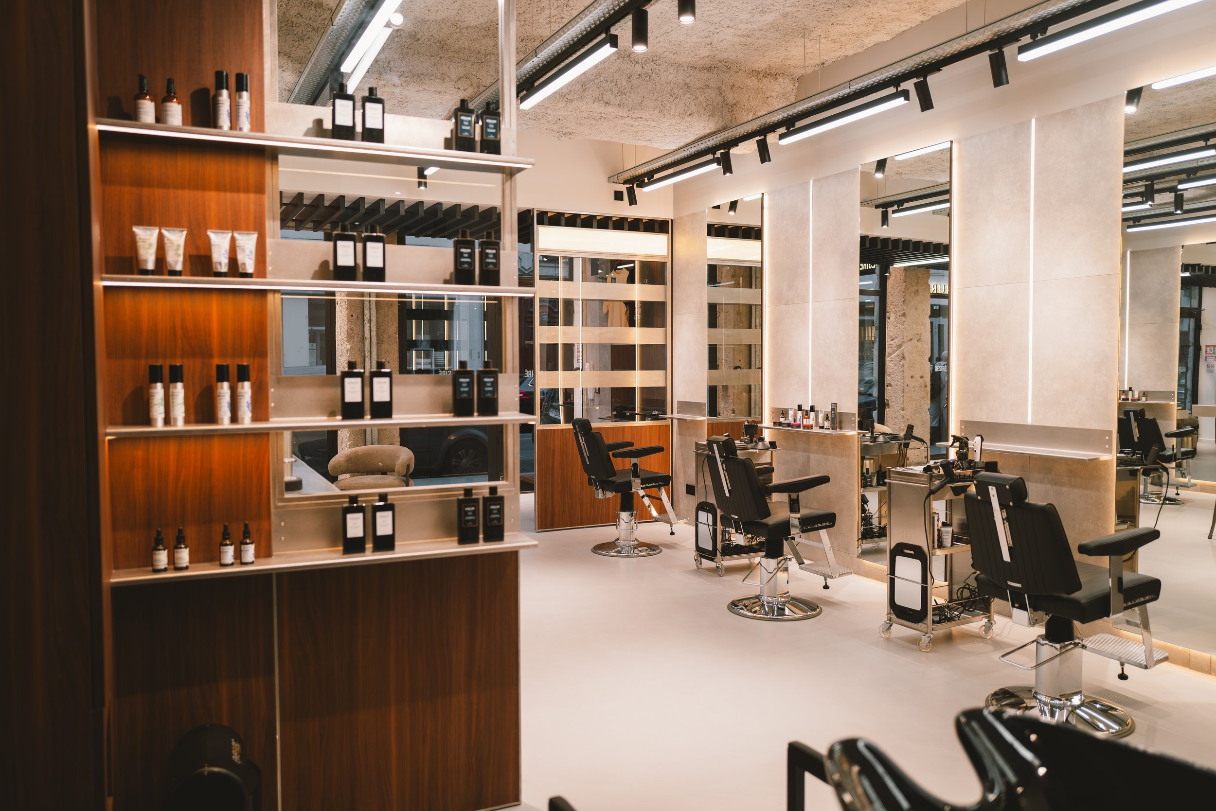 Intérieur d'un salon de coiffure moderne avec des miroirs, des fauteuils de coiffure et des étagères avec des produits capillaires.