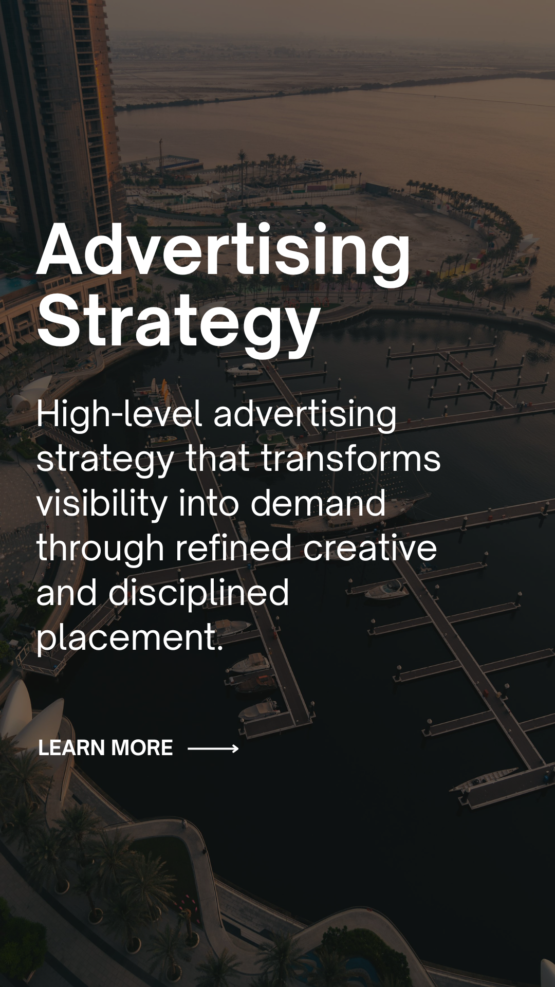 Aerial view of a marina with boats docked, surrounded by high-rise buildings and a waterfront promenade during sunset.