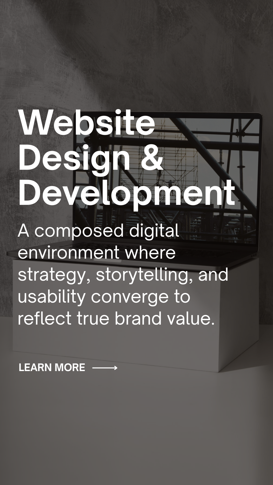 Screen showing text about website design and development with a laptop in the background on a stand.