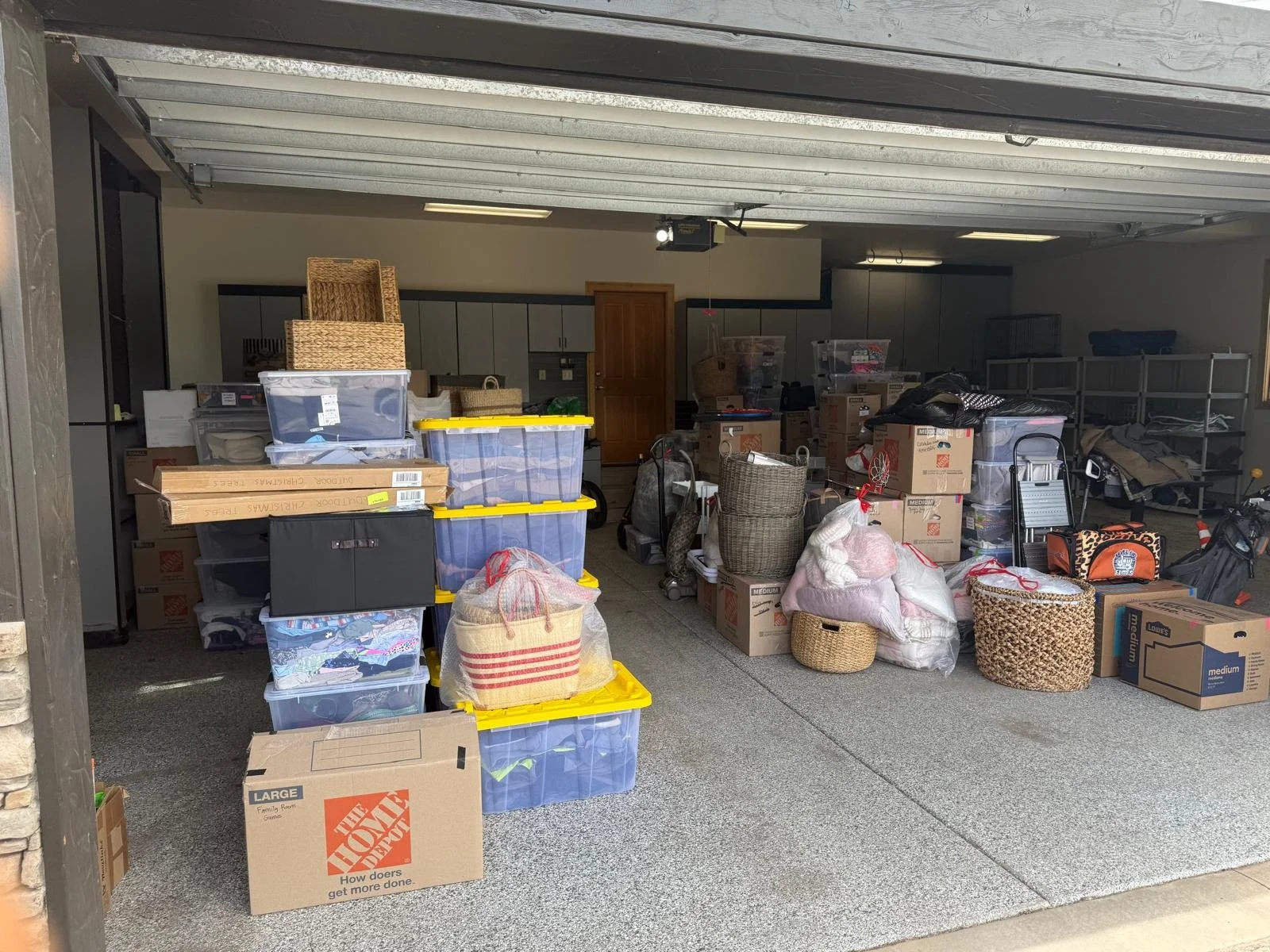 A garage filled with moving boxes, plastic storage bins, and household items.