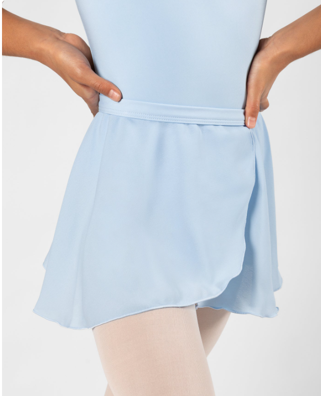 Close-up of a person wearing a light blue athletic skirt with hands on hips, beige tights, and a matching top.