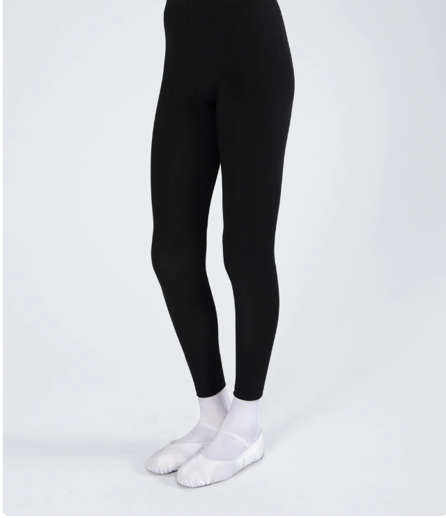 Person wearing black leggings, white socks, and white slip-on shoes, standing against a plain background.