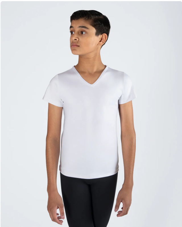 A young woman with short dark hair wearing a white V-neck T-shirt and black pants, standing against a plain light gray background.