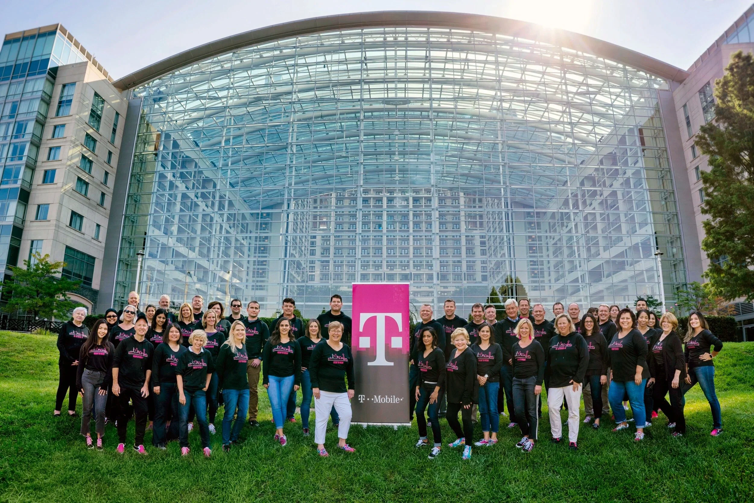 a group of people standing behind a big glass building