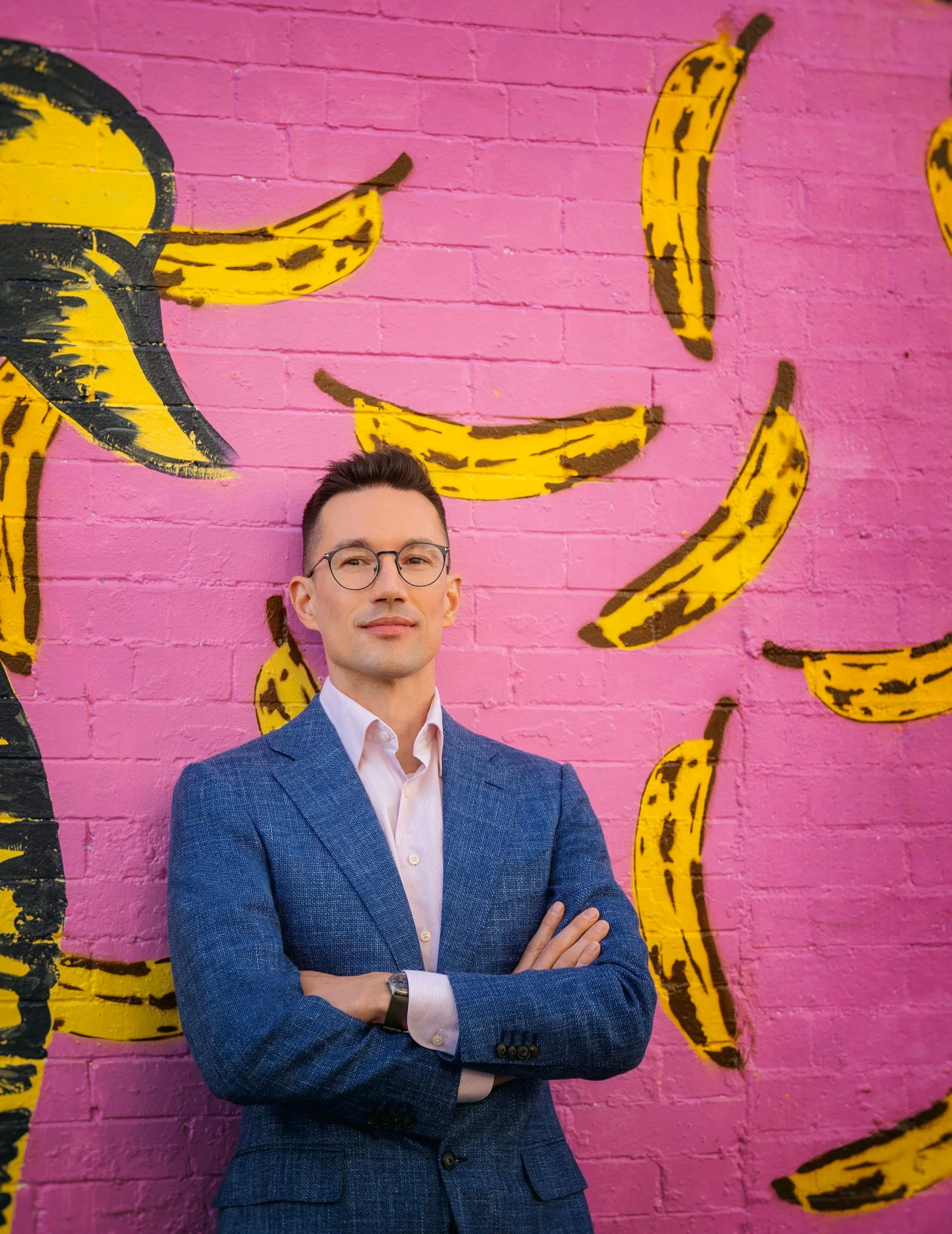 Man standing behind a banana graffity
