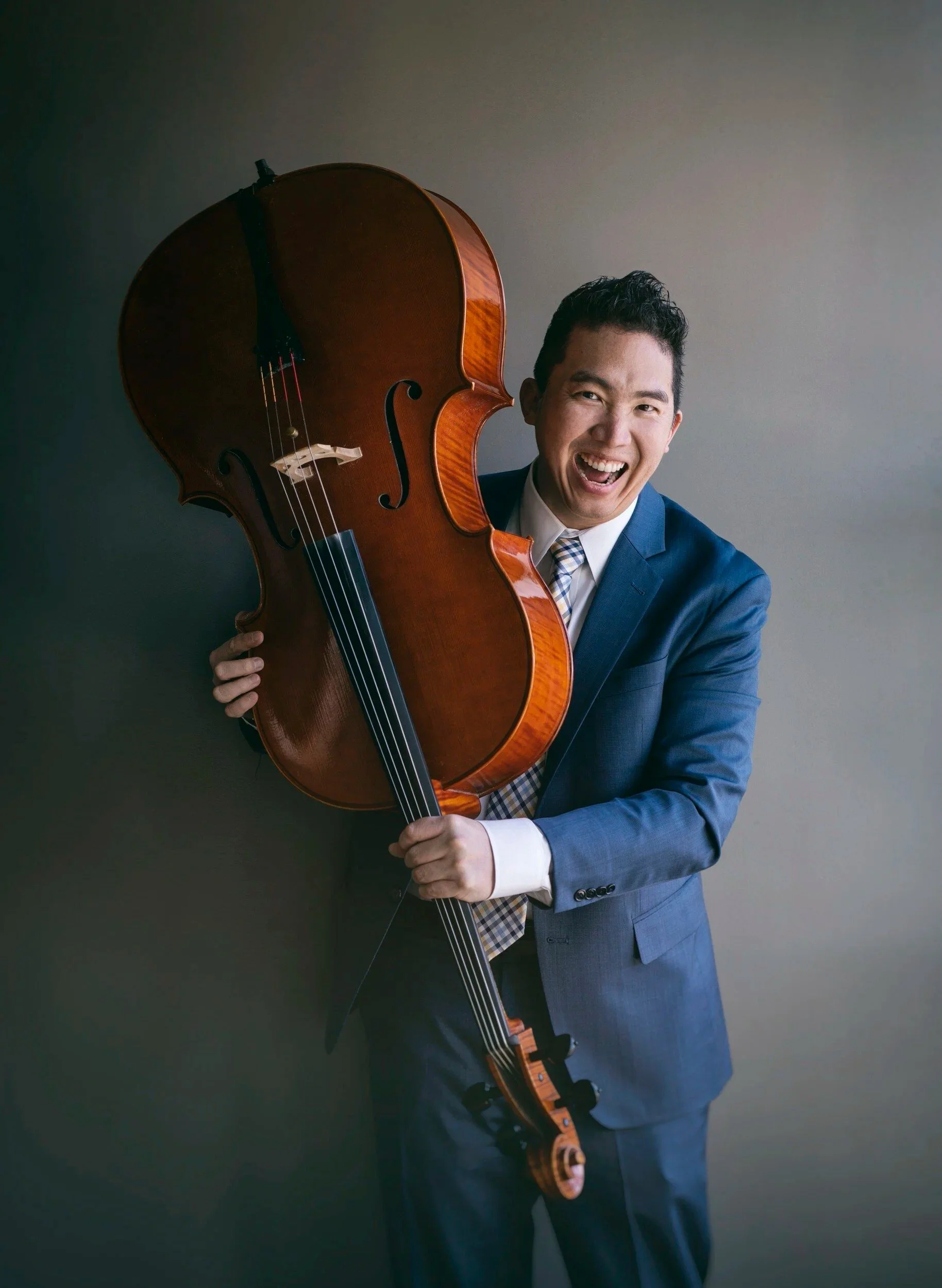 Man laughing while holding a instrument.