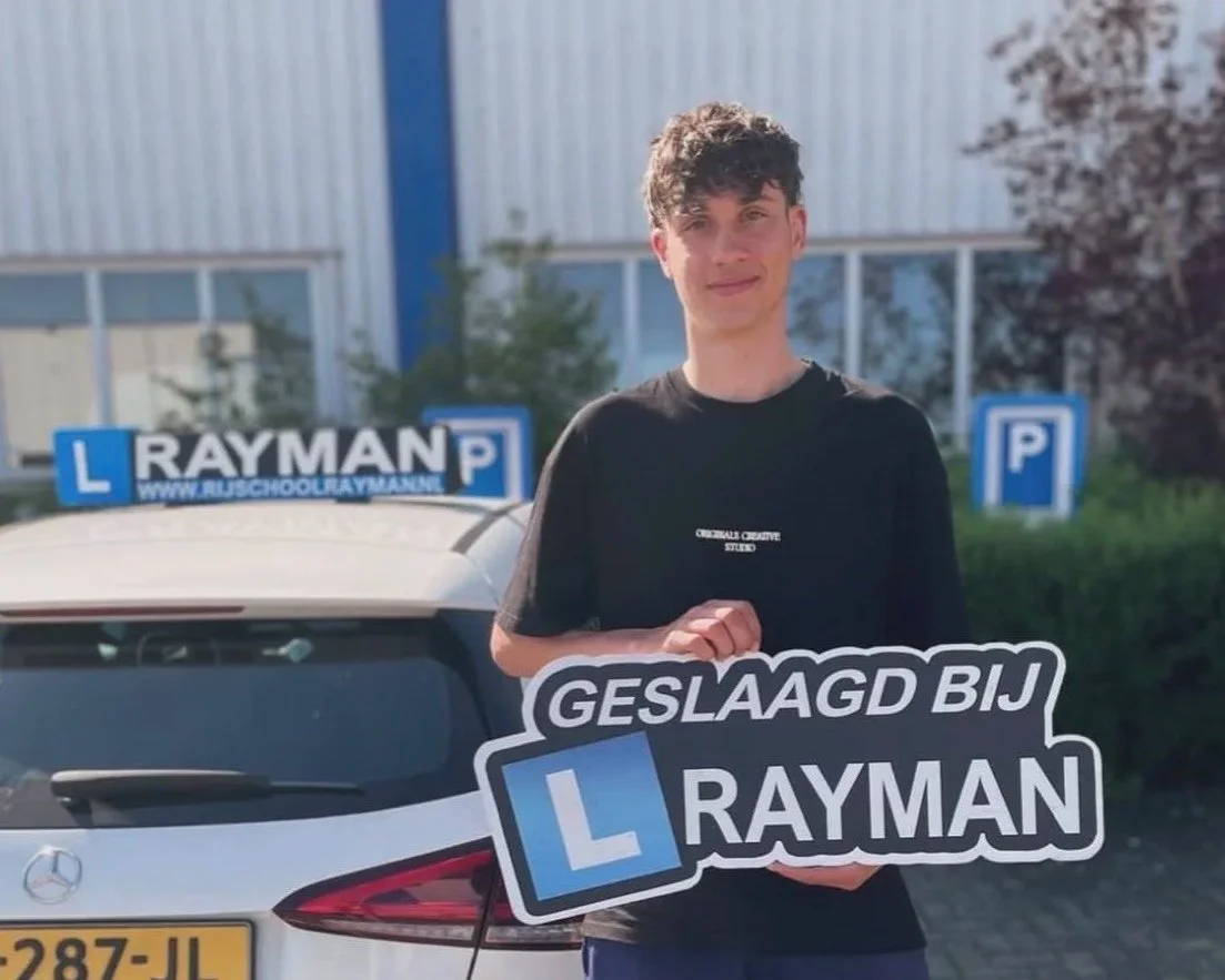 Man houdt een bord met tekst in een parkeerplaats met een auto op de achtergrond.