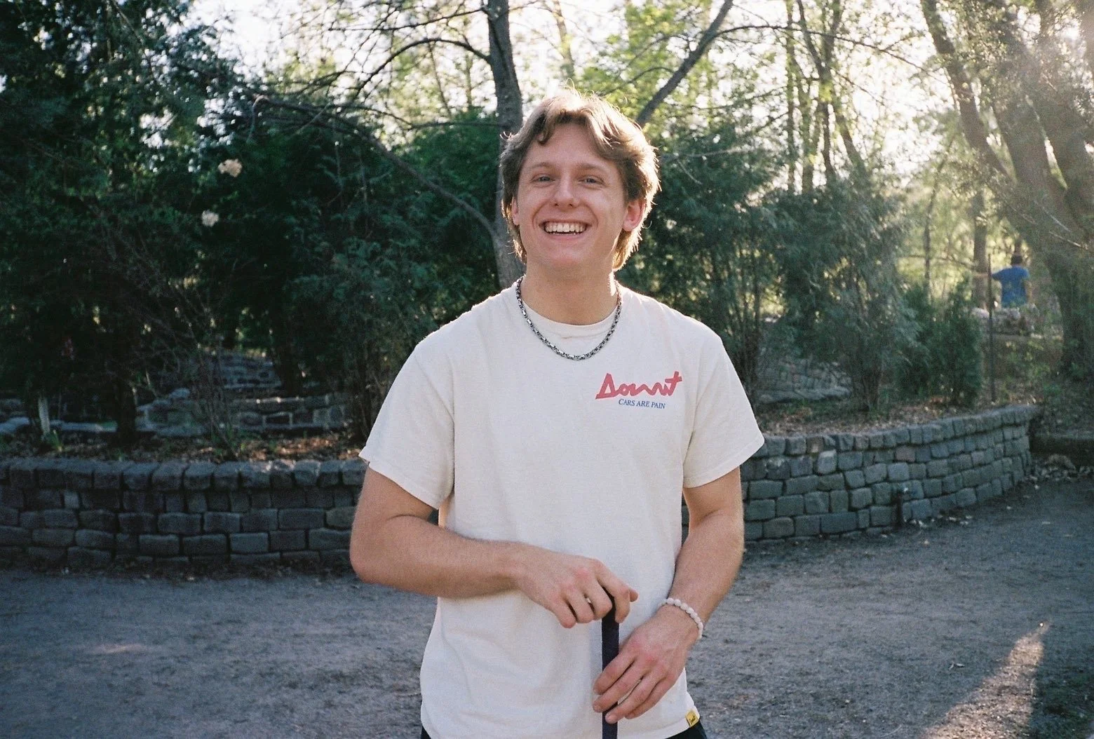 Young guy smiling, looking at the camera while holding a lanyard