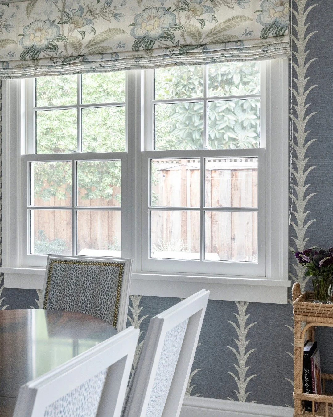 Wallpaper can completely transform a space, y'all, and this dining area is proof.

I love how this soft blue pattern adds just the right amount of movement and texture while still feeling calm and classic. Paired with the tailored roman shade and tho