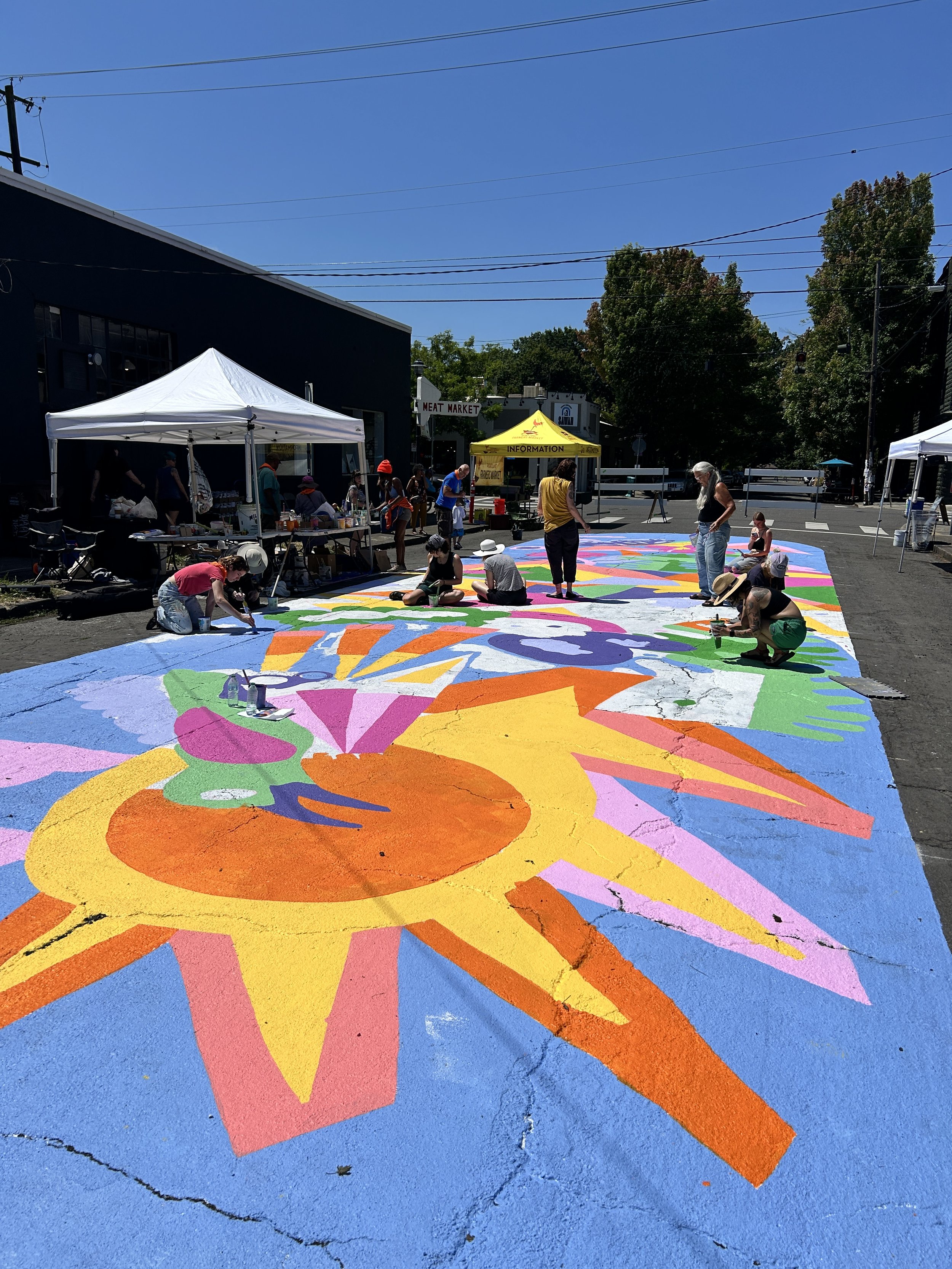 People painting an asphalt mural.