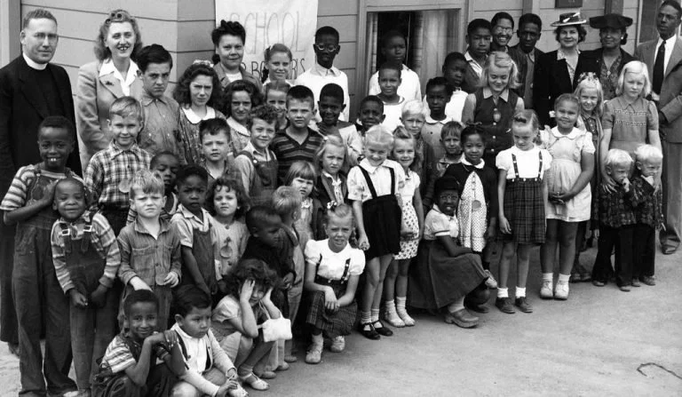 Black and white archival photo: Photo of elementary-aged children and their teachers.