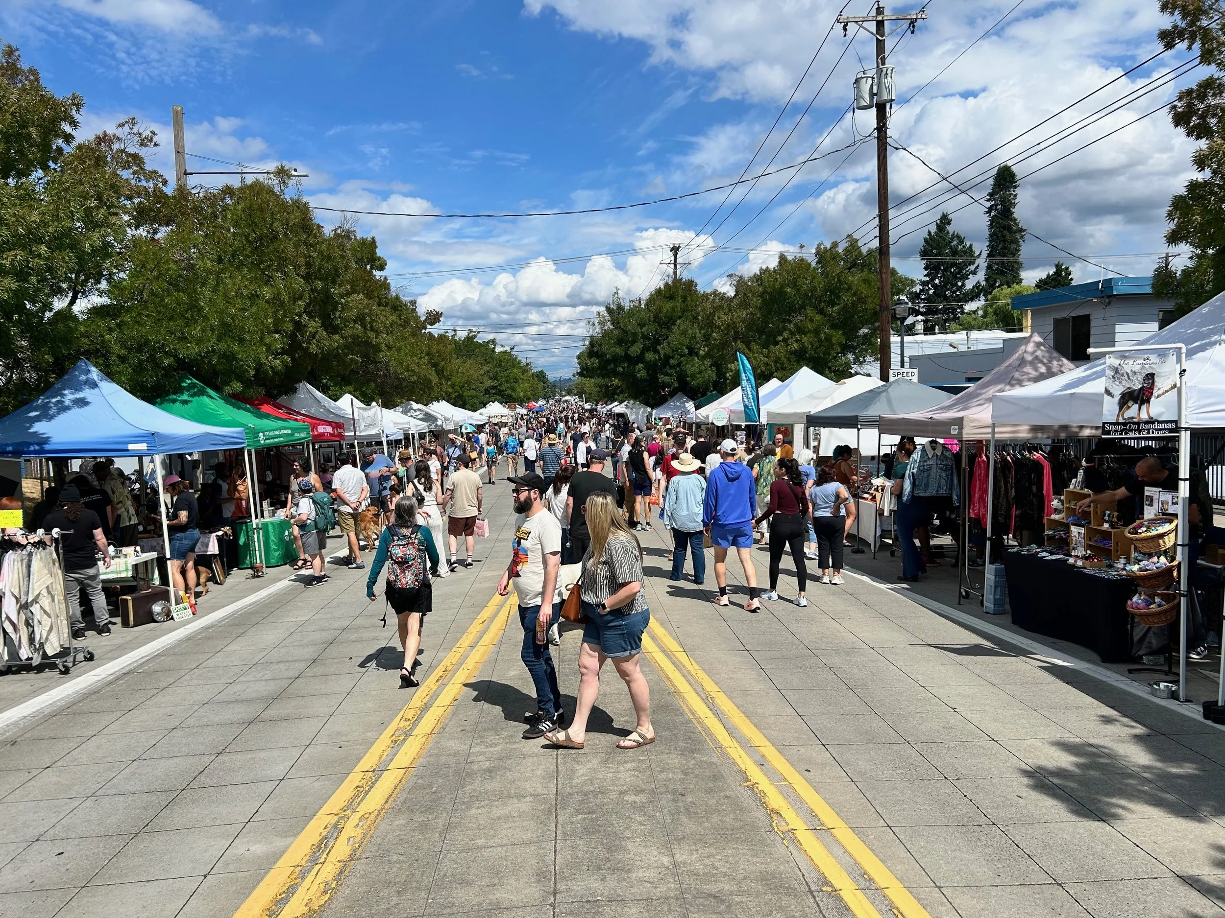 Vendor booths line both sides of N Denver and people walk along the street during the Kenton Street Festival.