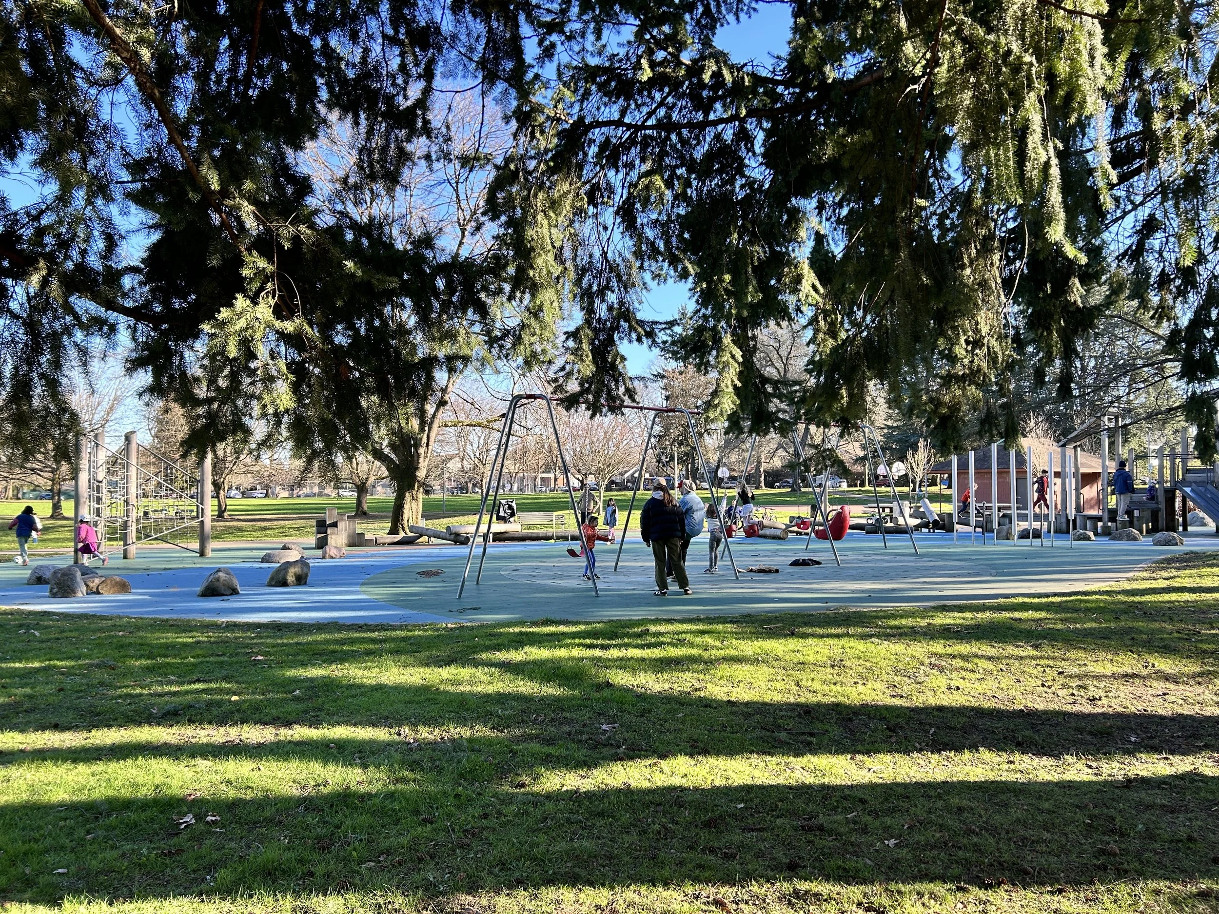 Families enjoying the playground at Kenton Park on a sunny day.