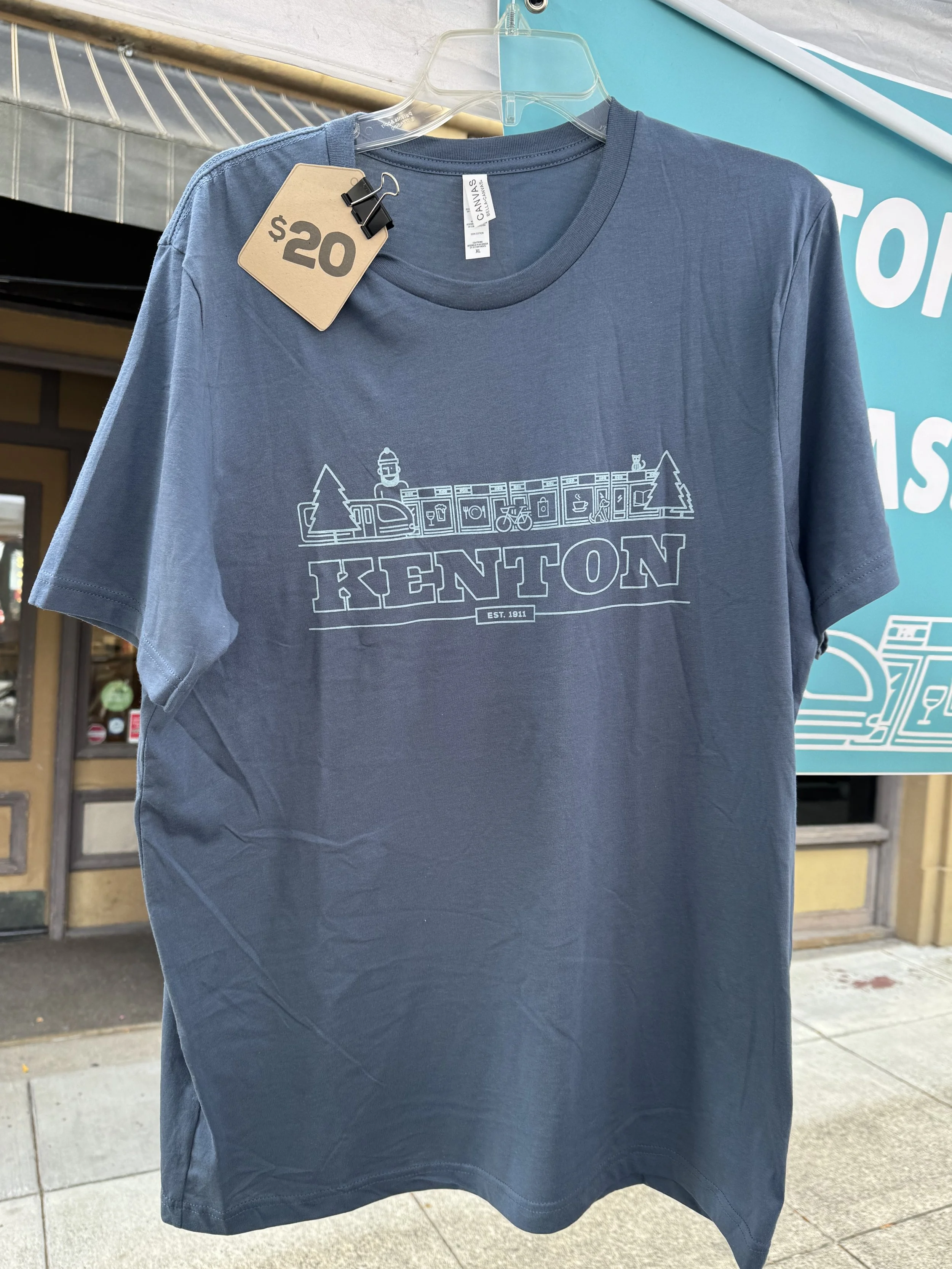 Blue T-shirt with the KNA logo screen printed in a light blue color.