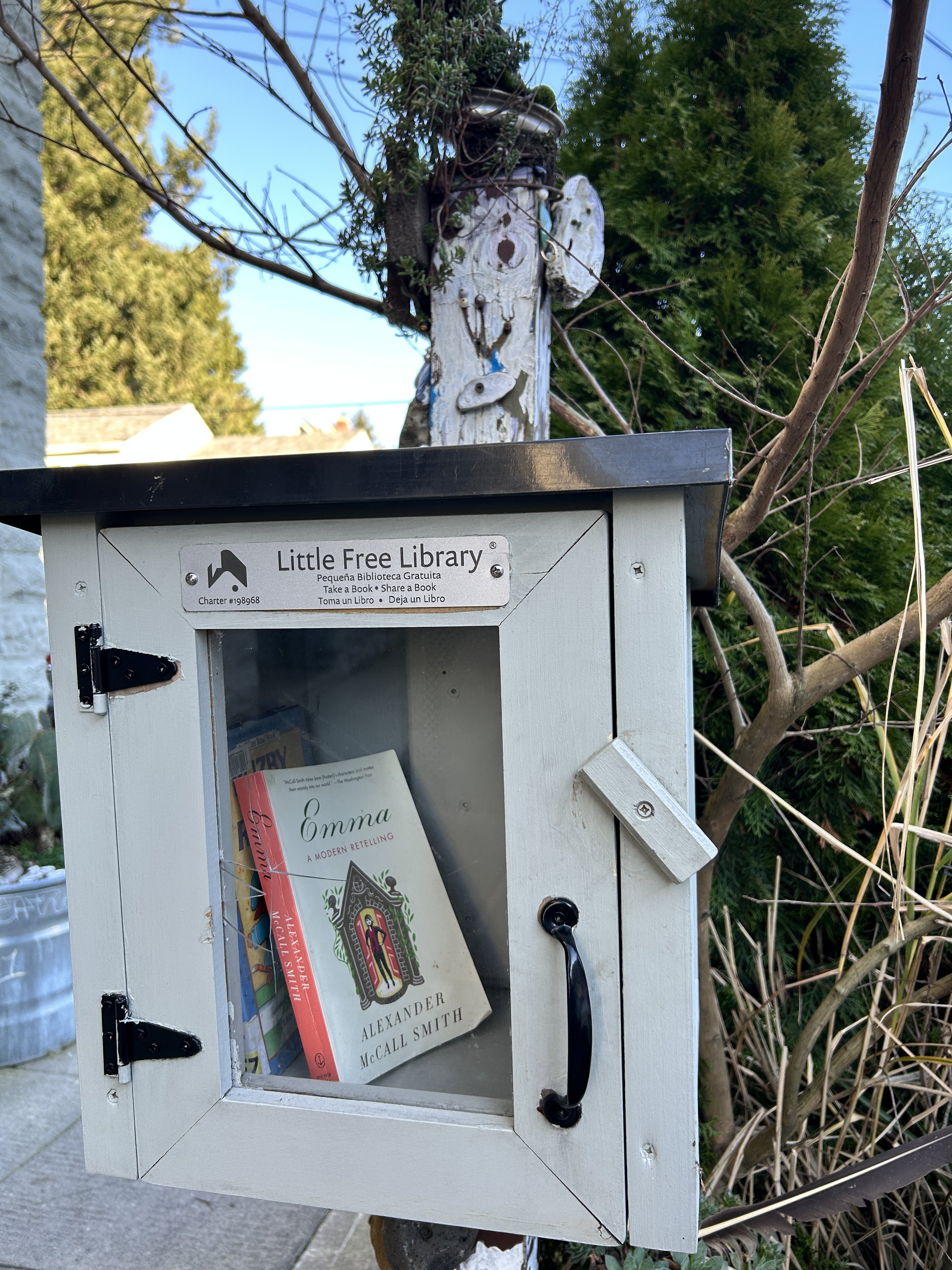 A little free library with a few books inside.