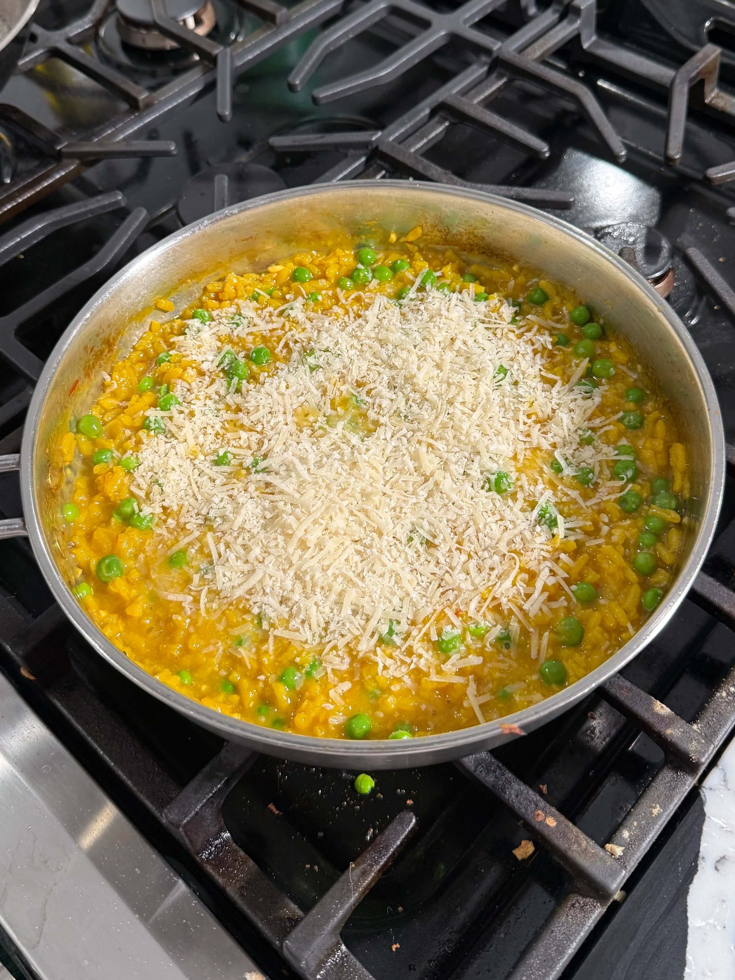 Saffron risotto finished with sweet peas and freshly grated Parmesan cheese.