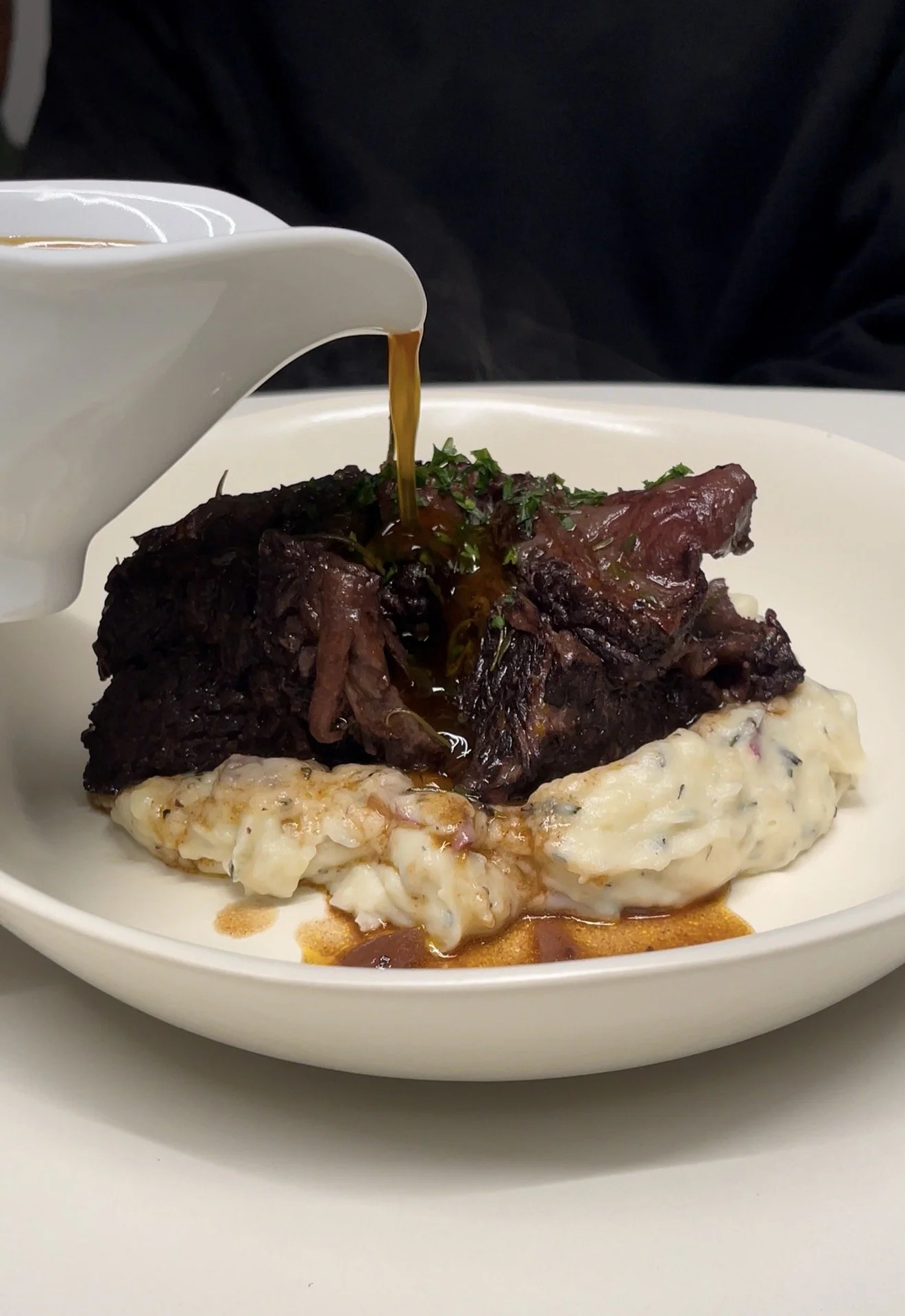 Plated slow-cooked braised beef with rich sauce and tender texture