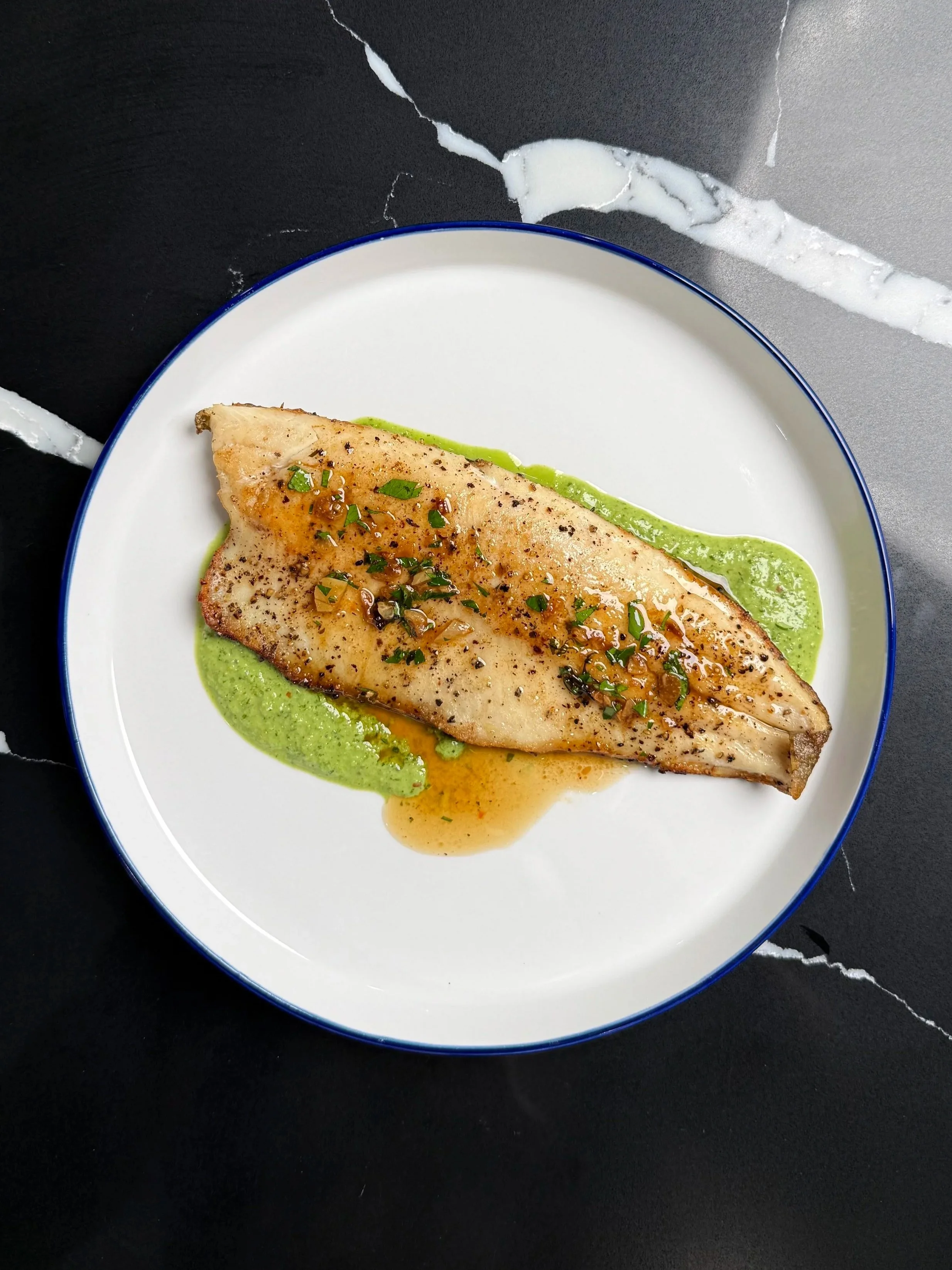 Pan-seared trout placed over parsley crème fraîche purée during plating