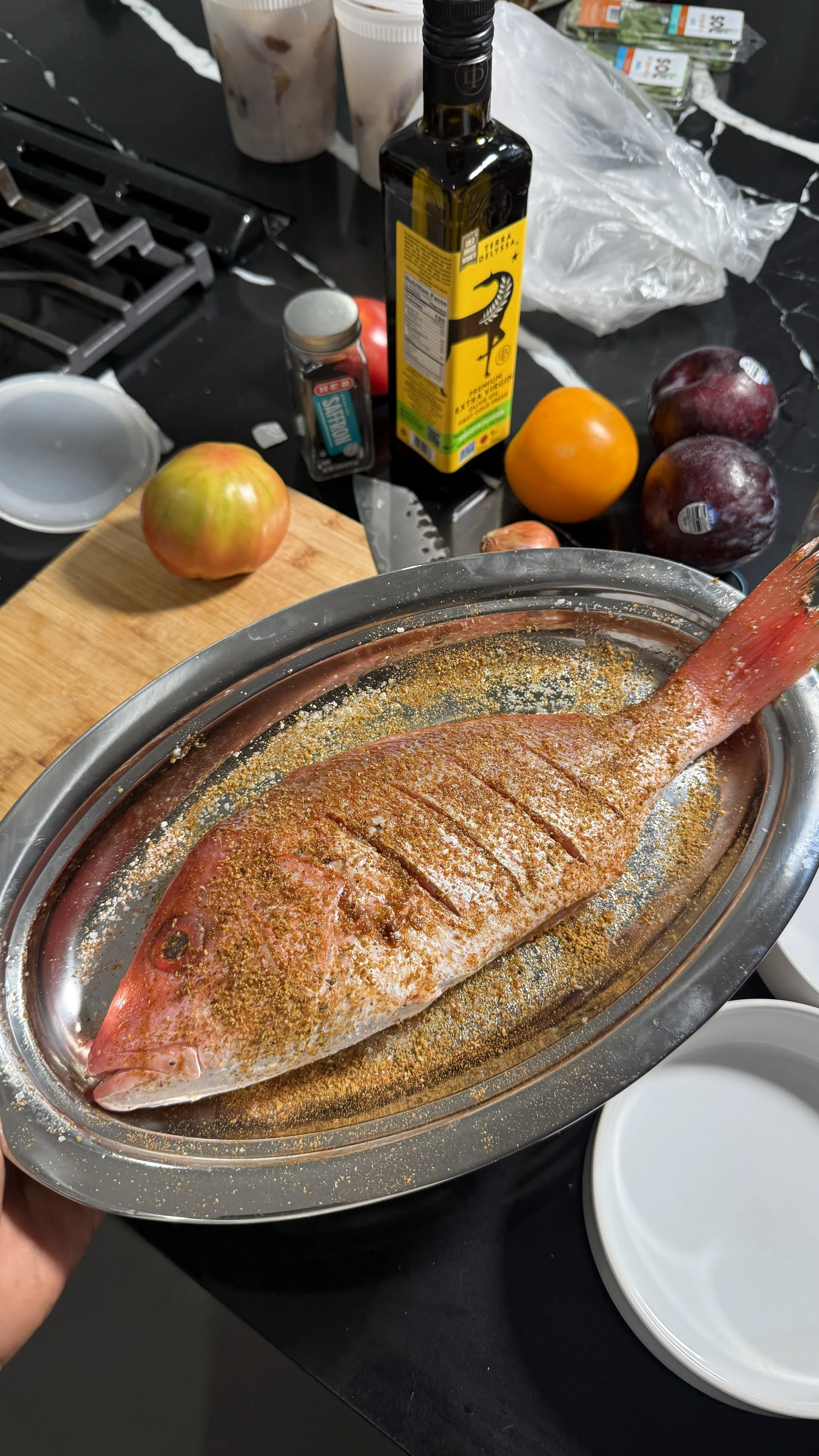 Whole snapper seasoned and scored before grilling