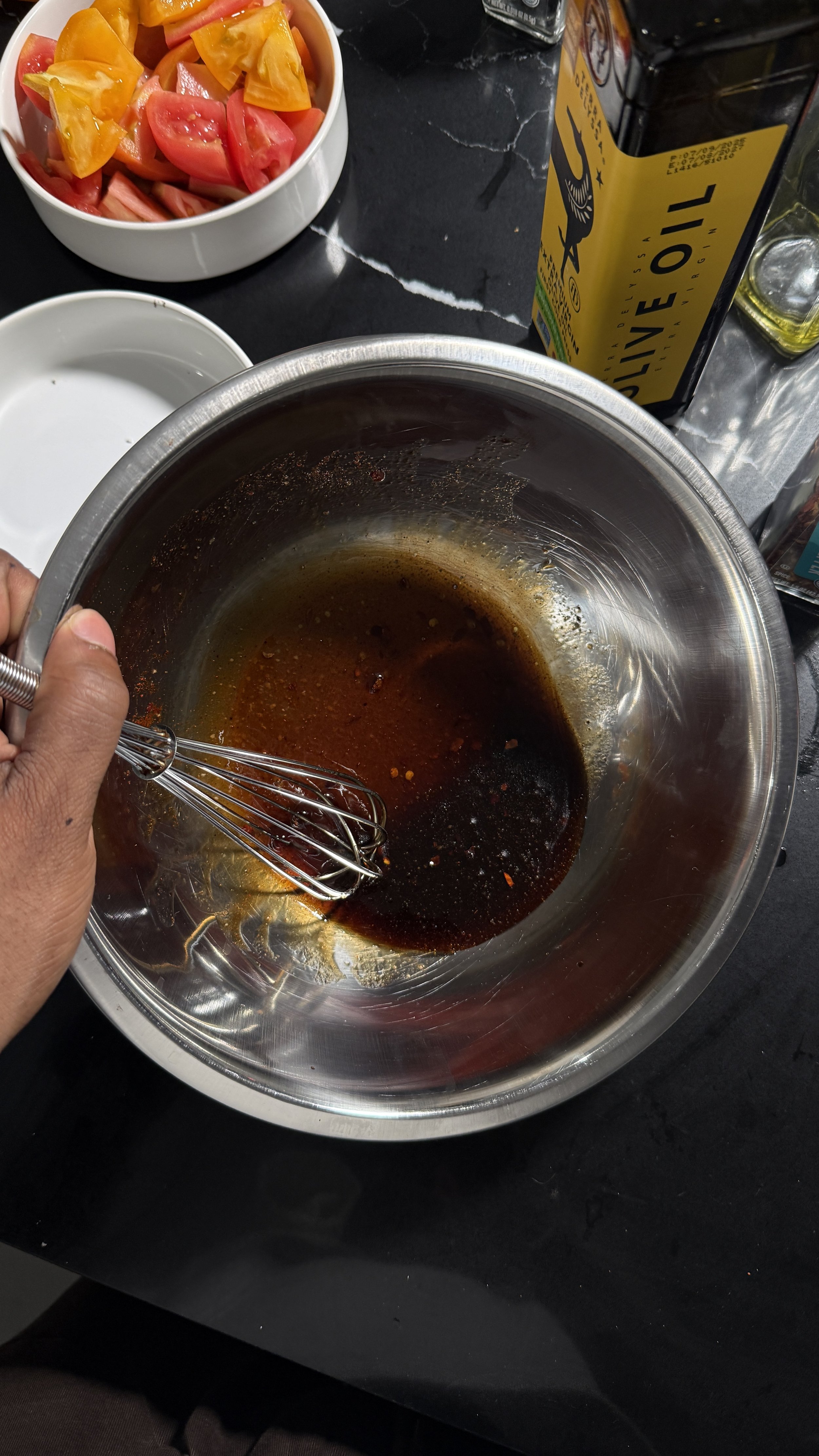 Mixing balsamic vinegar, olive oil, honey, and spices in a bowl
