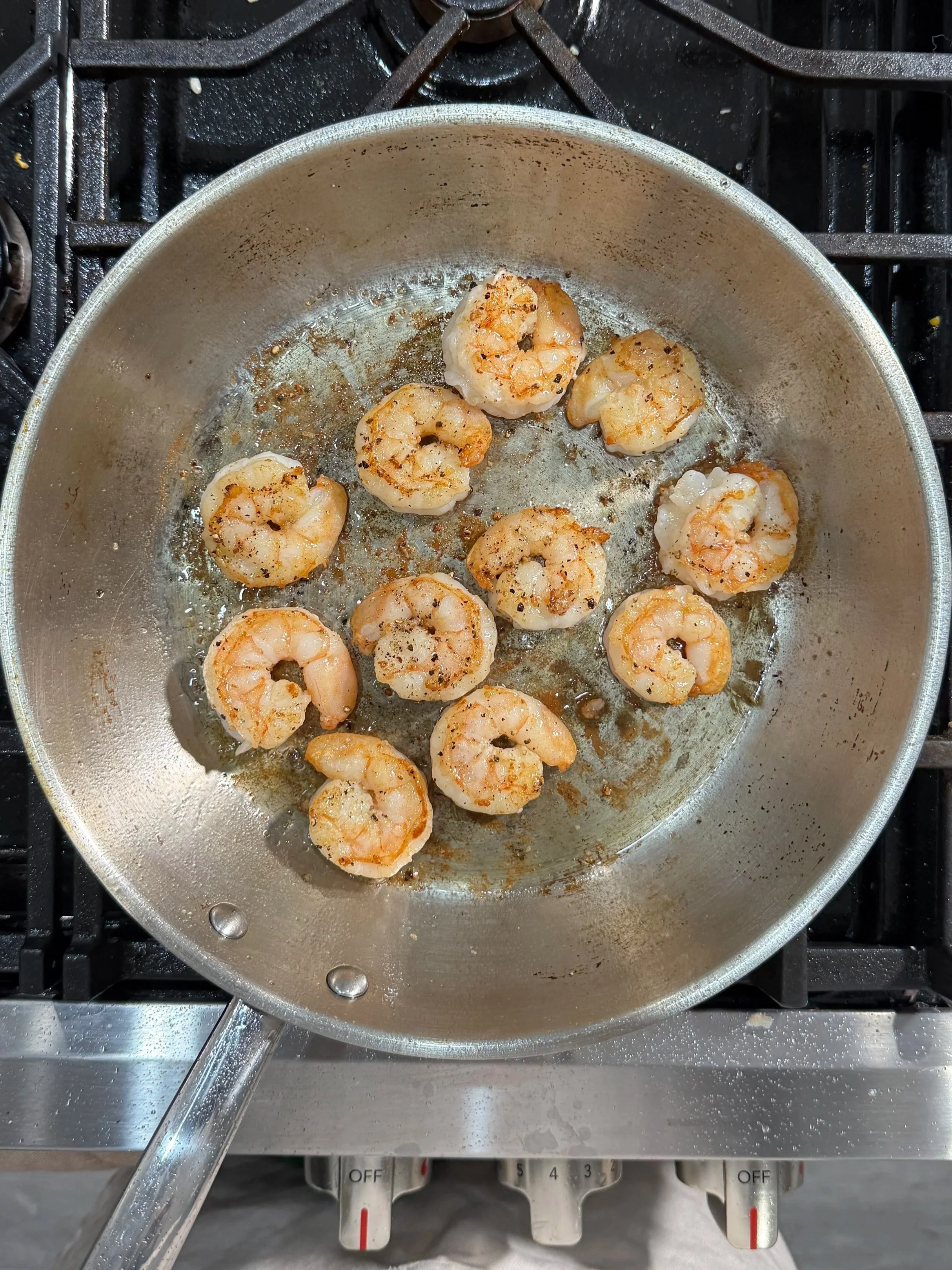 Shrimp searing in a skillet until golden brown.