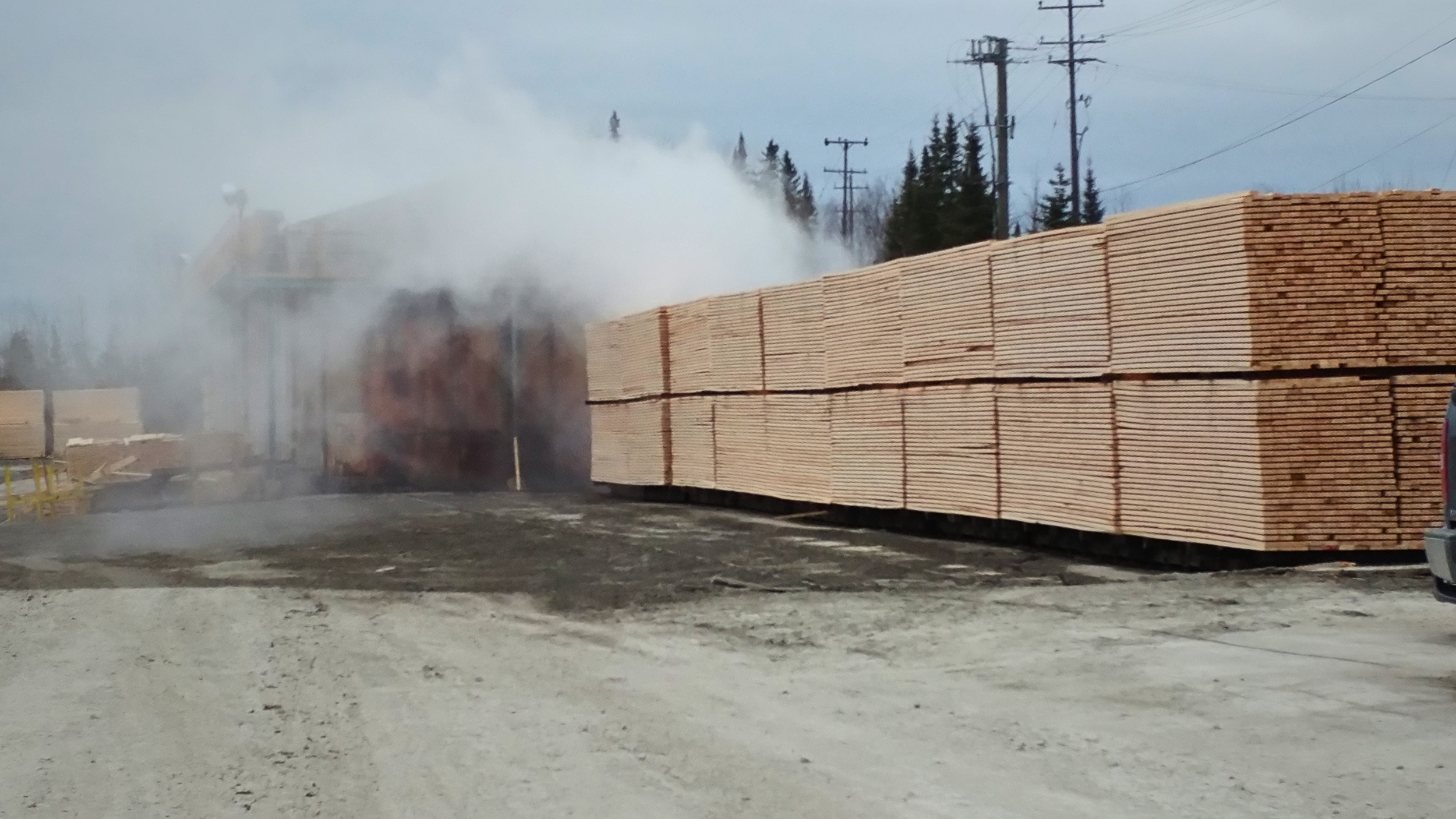 A landscape with snow-capped mountains in the background and a modern building on a grassy hillside in the foreground.