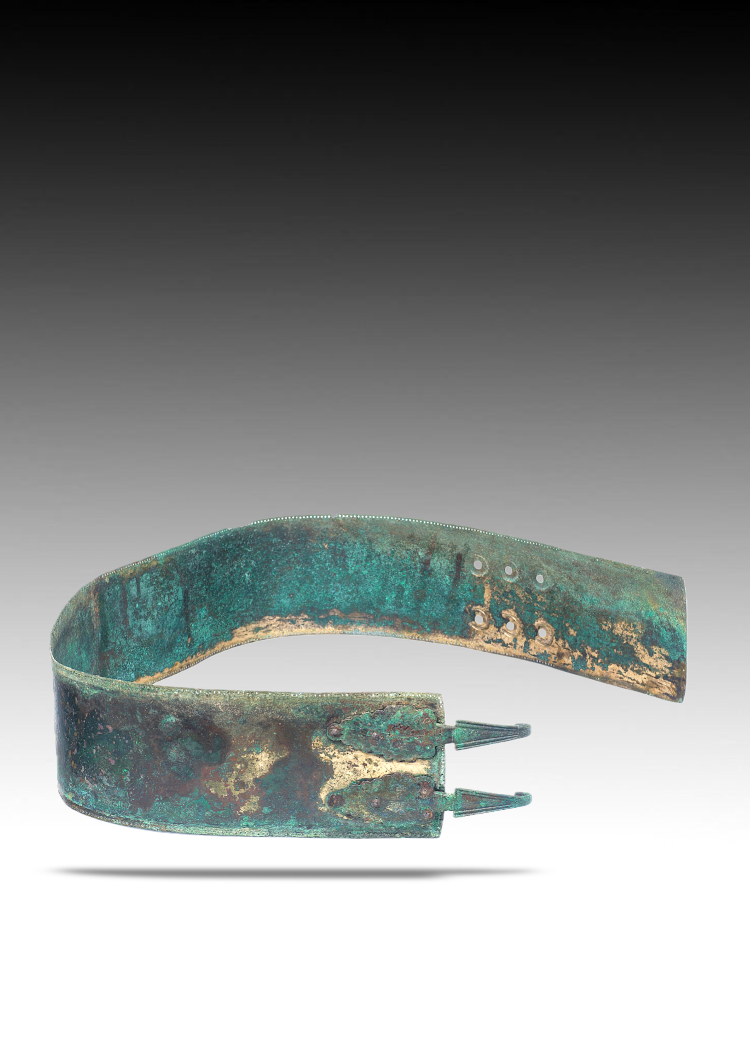An ancient bronze artifact, possibly a fragment of armor or a decorative piece, with a patina indicating age.