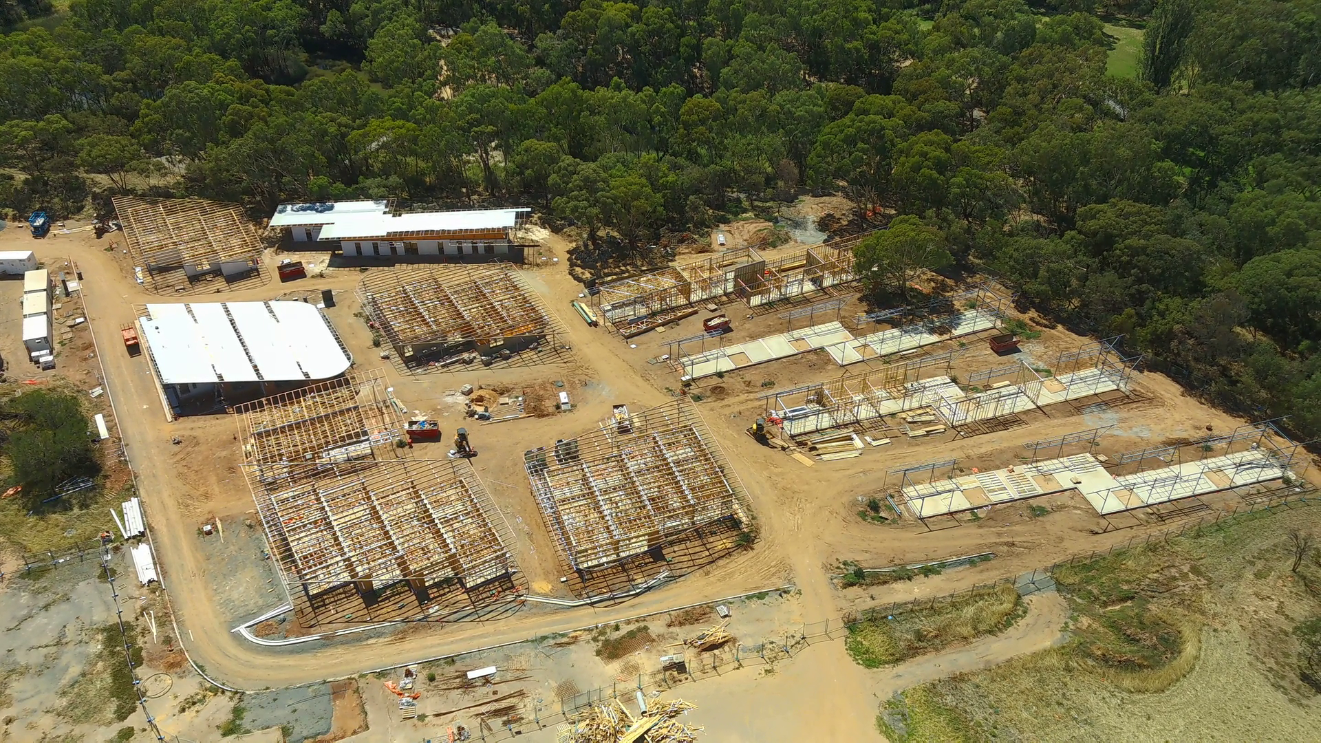 Aerial view of a master-planned residential development under construction showing building frames, road networks and staged site development.