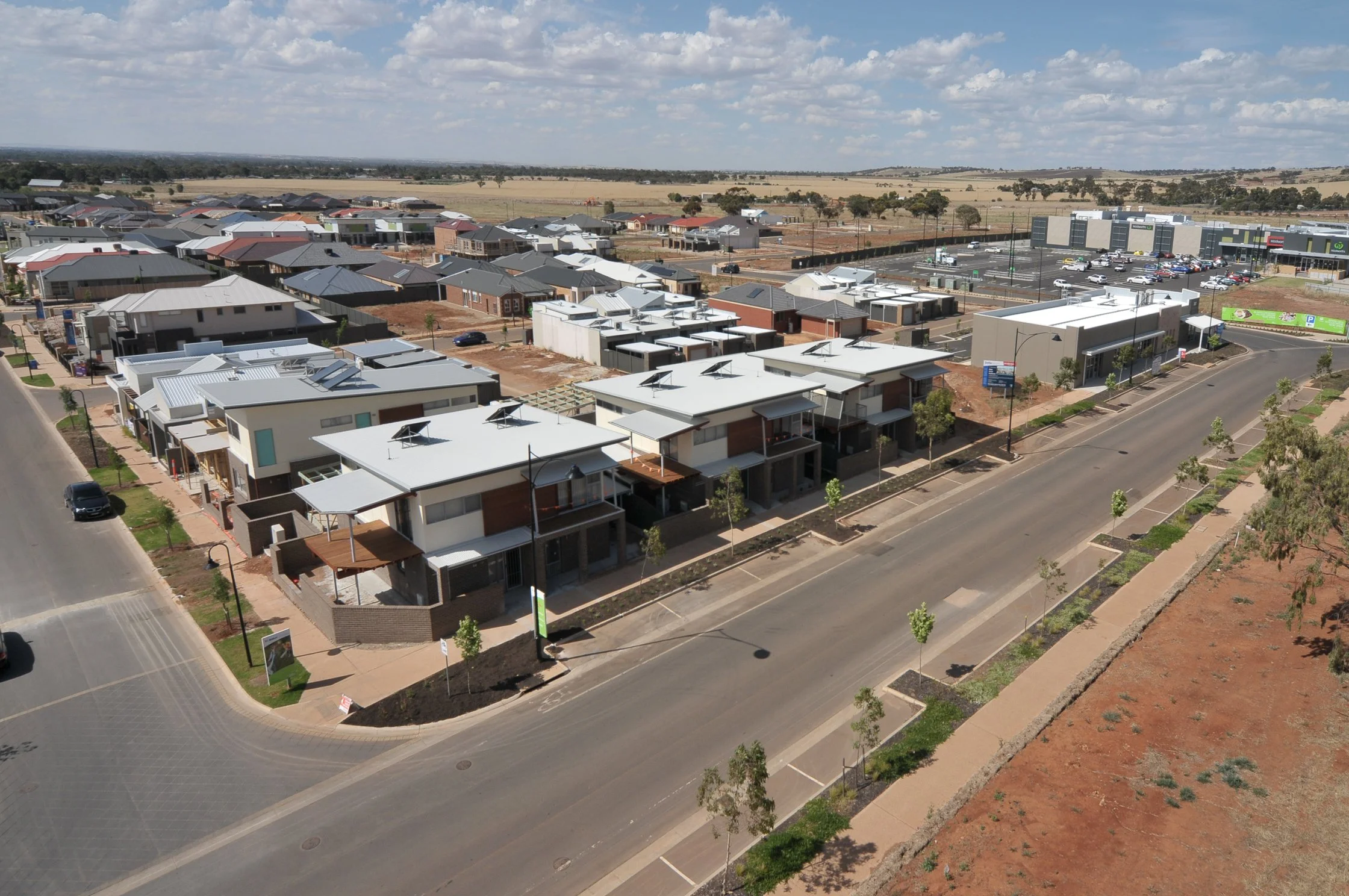 Aerial view of a contemporary residential neighbourhood featuring medium-density housing, landscaped streetscapes and integrated urban planning.