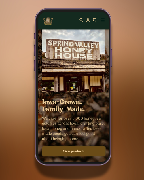 Smartphone displaying a website for Spring Valley Honey House, a local honey business in Iowa. The page features an image of the honey house, with text about their family-made, local honey and honeybee products.
