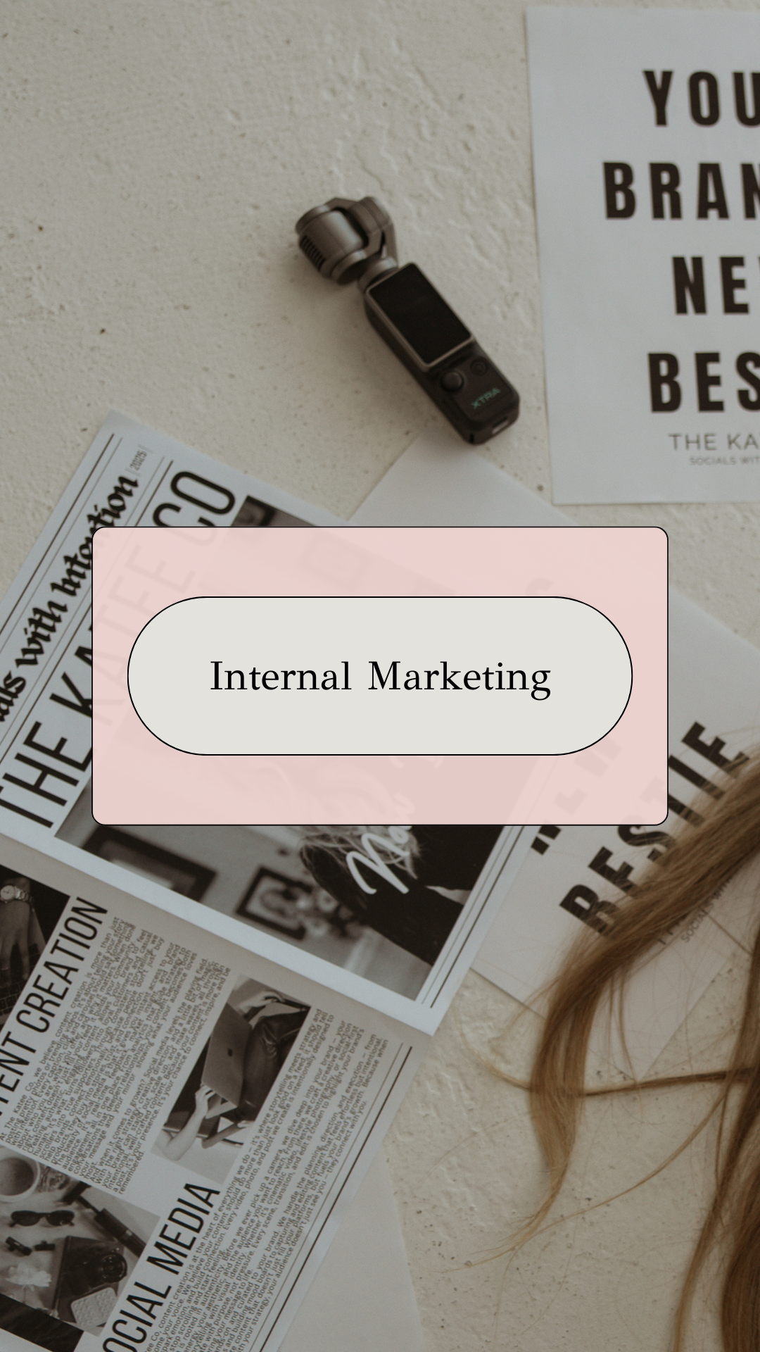Flat lay of a newspaper, a voice recorder, and a piece of paper on a textured surface with a pink overlay labeled "Internal Marketing."
