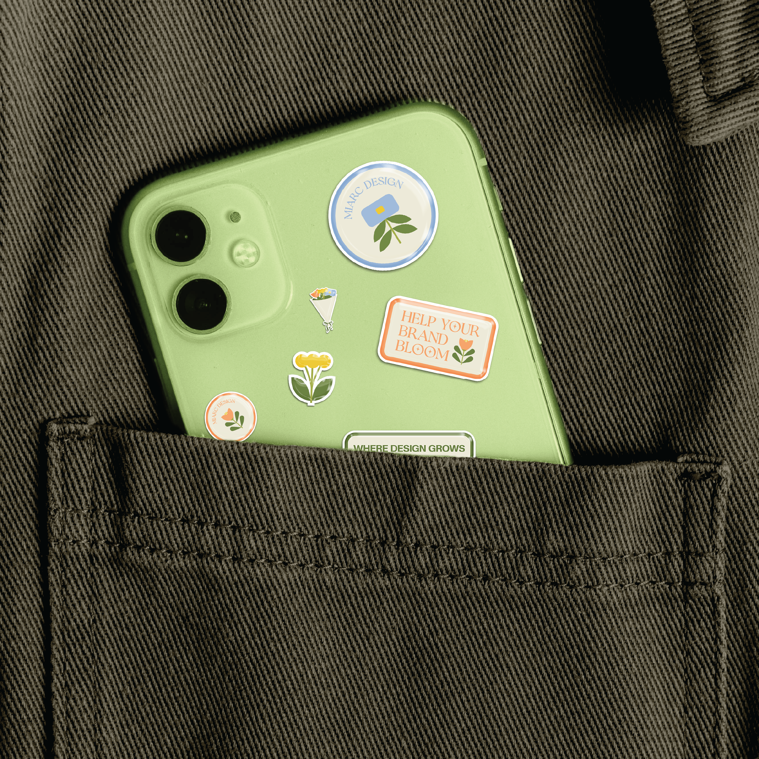 A green smartphone with several plant-themed stickers, partially visible, placed in the front pocket of dark brown fabric.