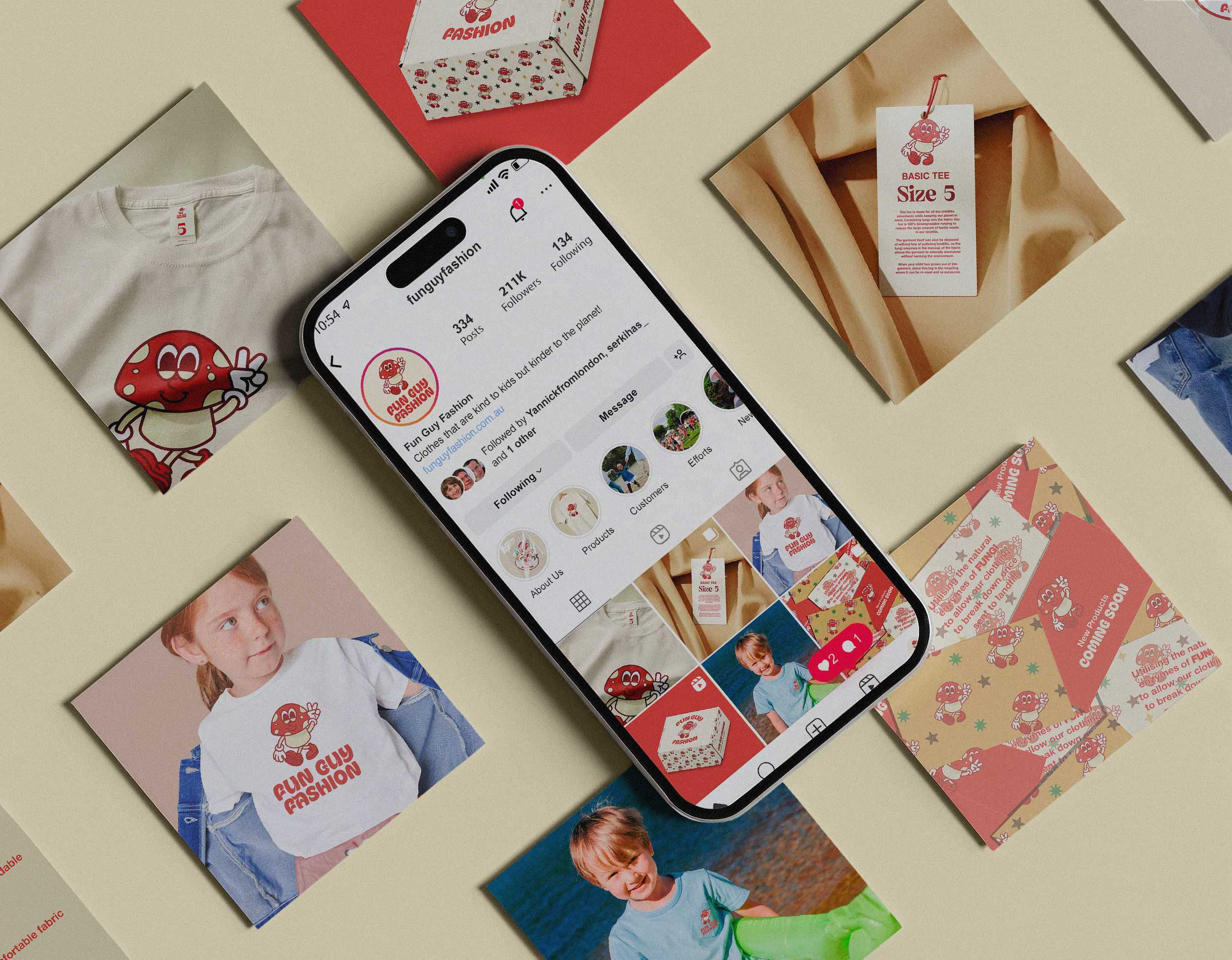A flat lay of various merchandise and printed materials surrounding a smartphone displaying an Instagram profile for Fun Guy Fashion, a children's clothing brand. Items include a white T-shirt with a mushroom character, postcards, boxes with mushroom motifs, and photos of children wearing Fun Guy Fashion clothing.