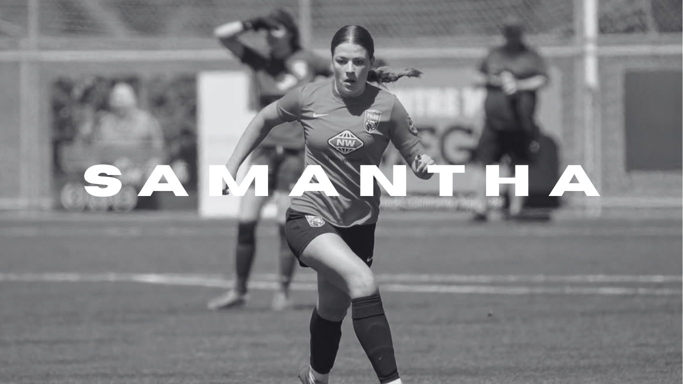 Black and white image of a female soccer player in uniform running on a field, with a coach or referee in the background.