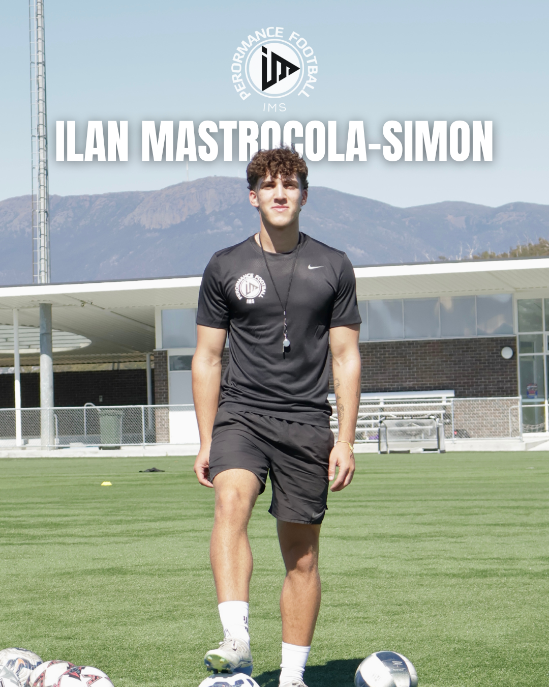 A young man standing on a soccer field with soccer balls at his feet, wearing black athletic clothing, a whistle around his neck, and a backdrop of a soccer stadium and mountains. The image promotes Ilan Mastrocola-Simon, a football coach or player.